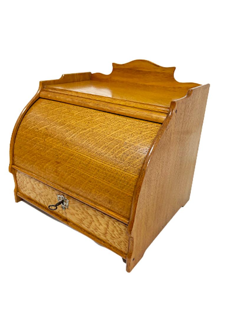 Une armoire à lettres de bureau en chêne hollandais avec un plateau rond coulissant. 

Un tiroir verrouillable à l'aide d'une clé, pour divers rangements, comprenant un compartiment pour les timbres. Le coin arrière gauche est légèrement