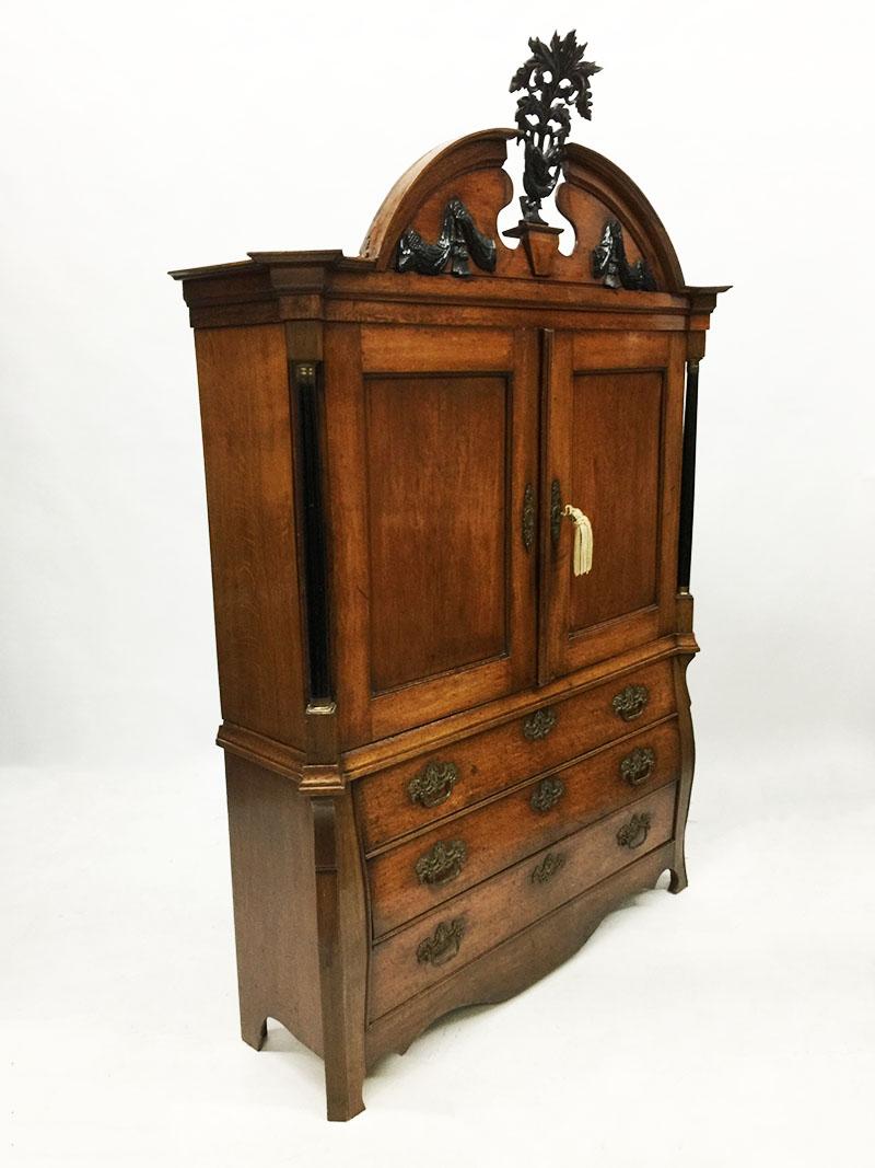 A Dutch oak very small cabinet from the period 1840-1860

A Dutch oak very small cabinet from the period 1840-1860, consisting of 2 parts. 
The upper part consists of 2 doors with interior of shelves and 3 small drawers. 
The bottom part has 3