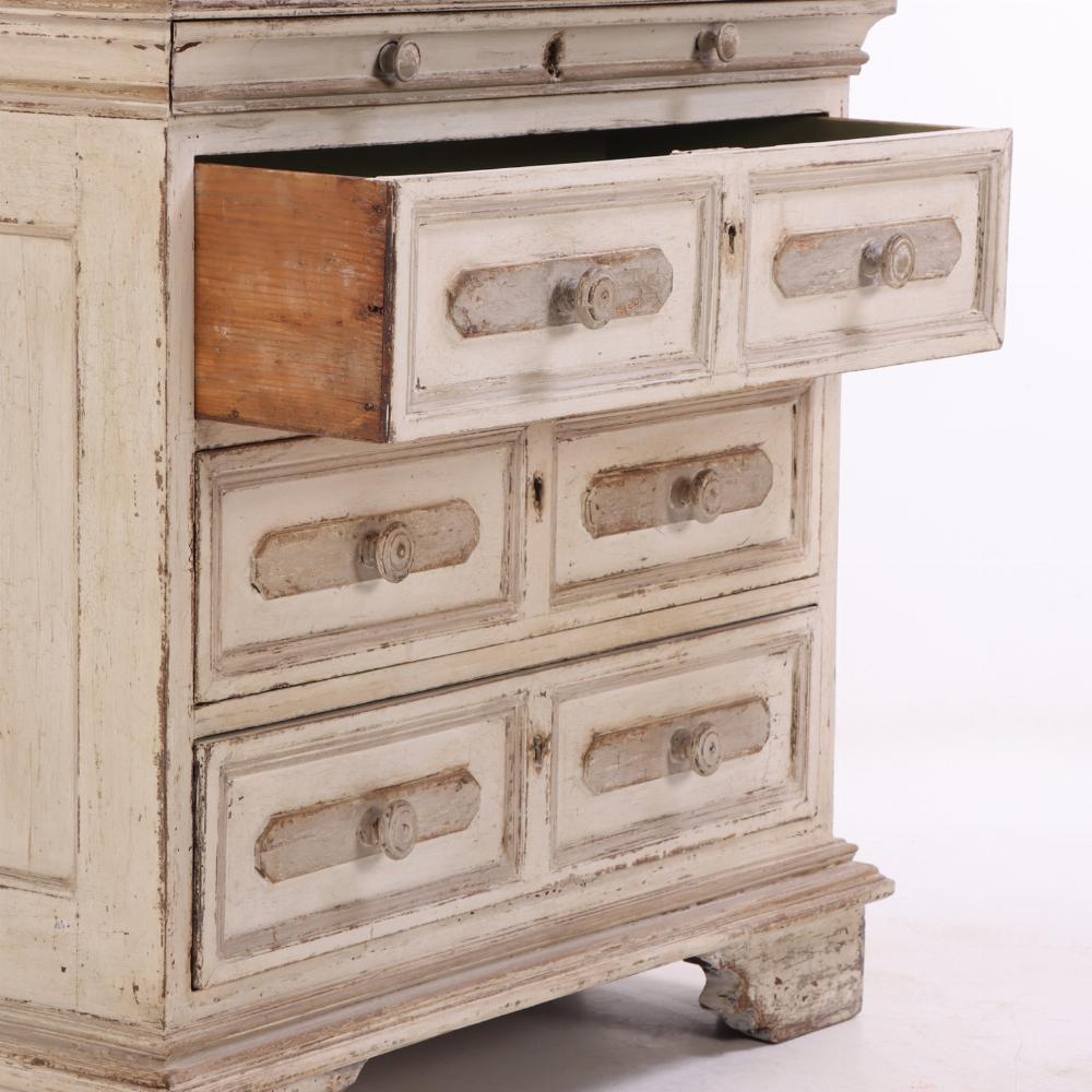 Elegante cómoda holandesa del siglo XVIII que presenta su acabado pintado original con una pátina suavemente envejecida. La encimera perfilada se asienta sobre un cajón poco profundo oculto, hábilmente integrado en la cornisa superior, manteniendo