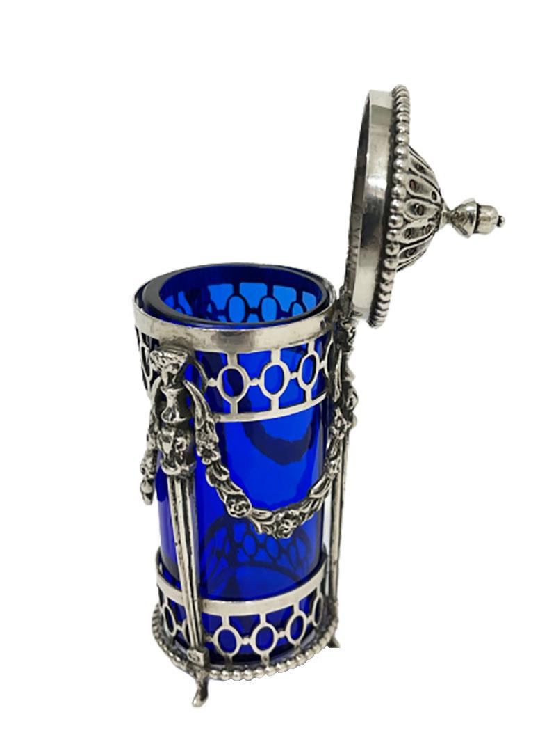 A Dutch silver and blue crystal glass spice spreader, 1845

A silver and blue crystal glass spice spreader dated from 1845. An openwork holder for the crystal bowl with flower garland, pearl rim and an acorn on the hinged cap, raised on 3