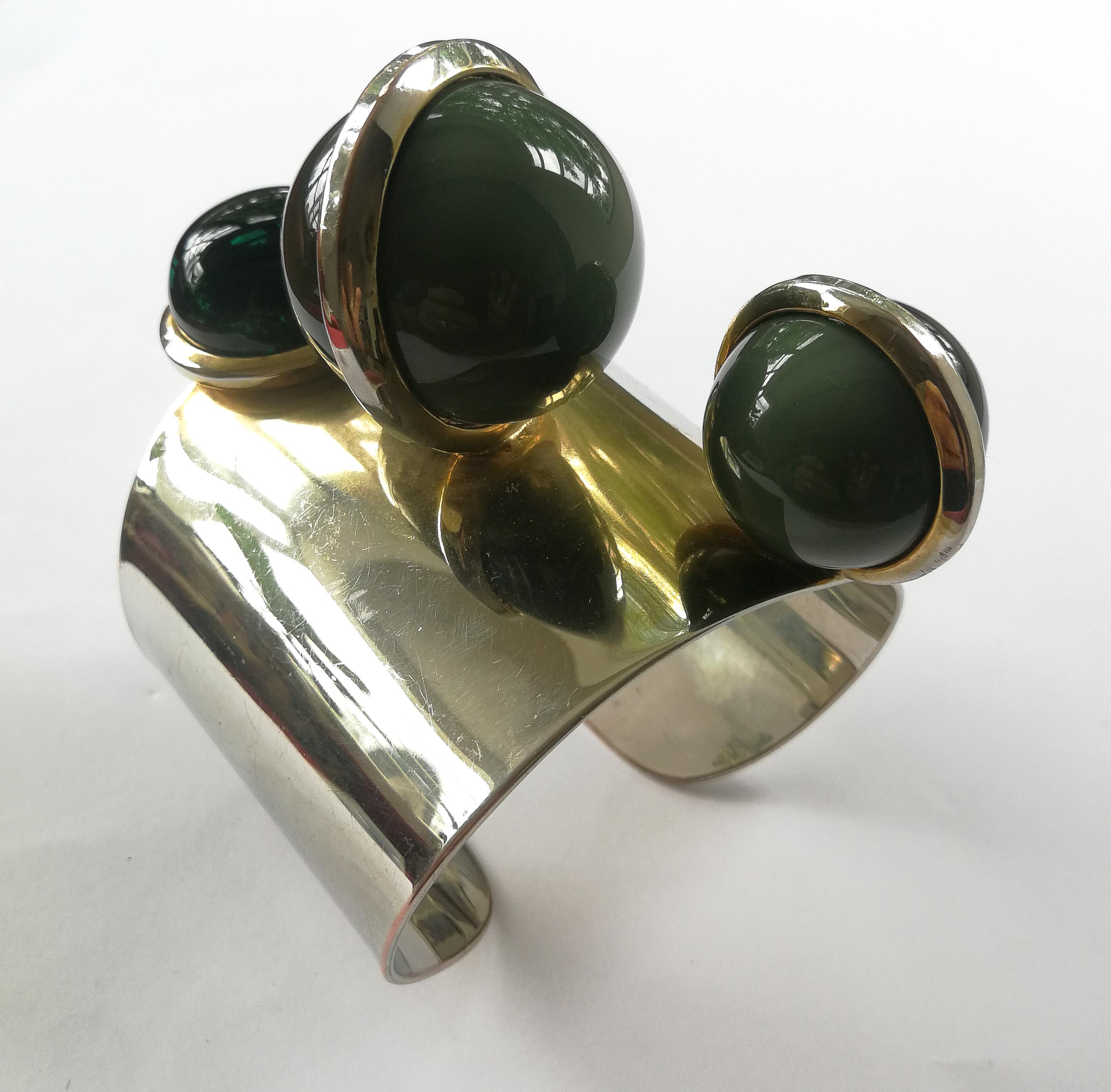 A very unusual, highly dynamic and most striking design makes this chrome metal bangle immediately eye catching, and a true conversation piece. The main body of this piece is a chromed bangle, showing some signs of a very soft gilding around the