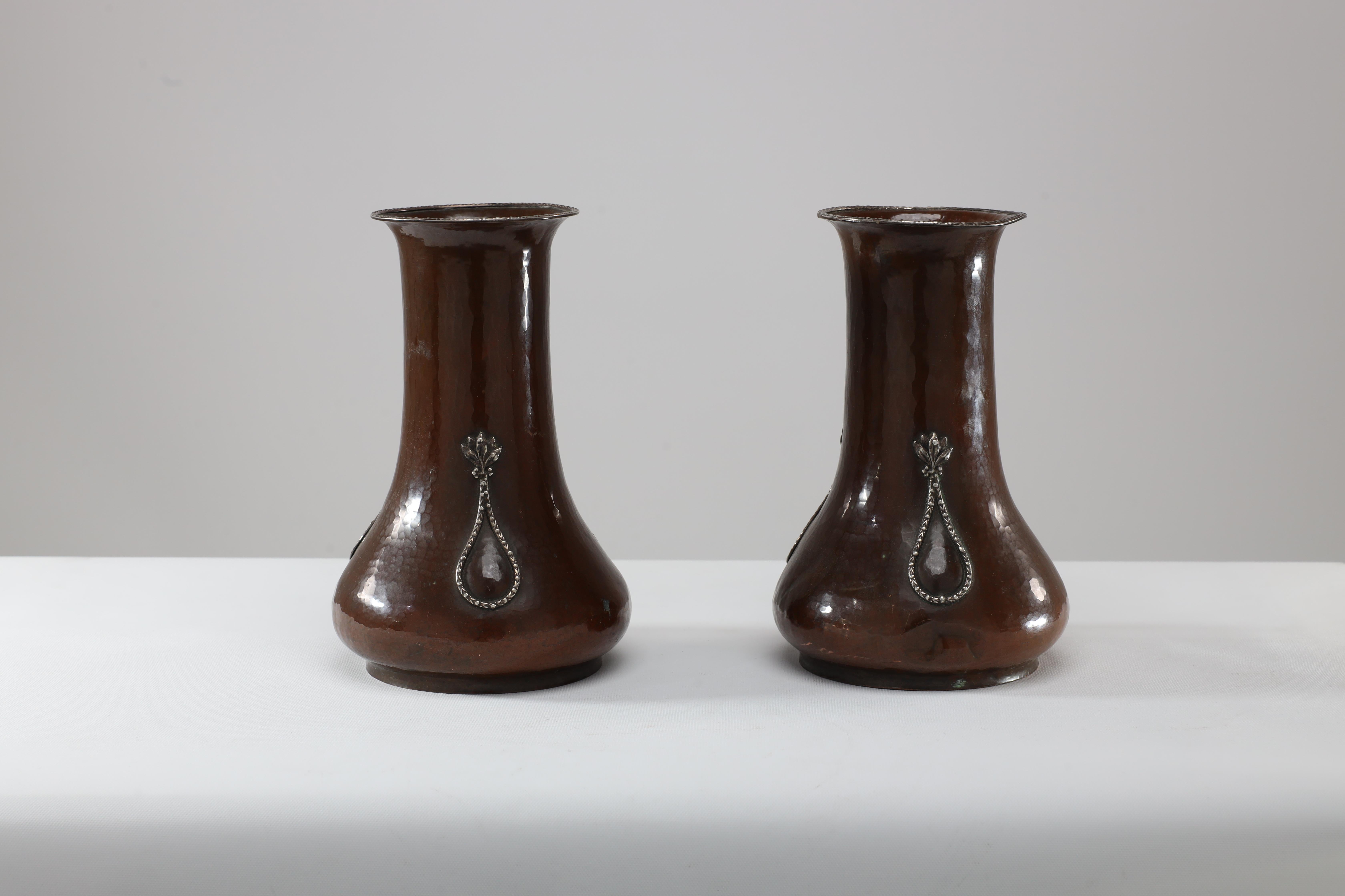 A E Jones. A pair of Arts and Crafts hand-hammered copper vases with silver teardrop decorationThe fine silver decoration to the rim and to the teardrop decoration is an egg and dart pattern, the teardrop surmounted with leaf detailing. A E Jones