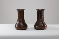 A E Jones. A pair of hand-hammered copper vases with silver teardrop decoration