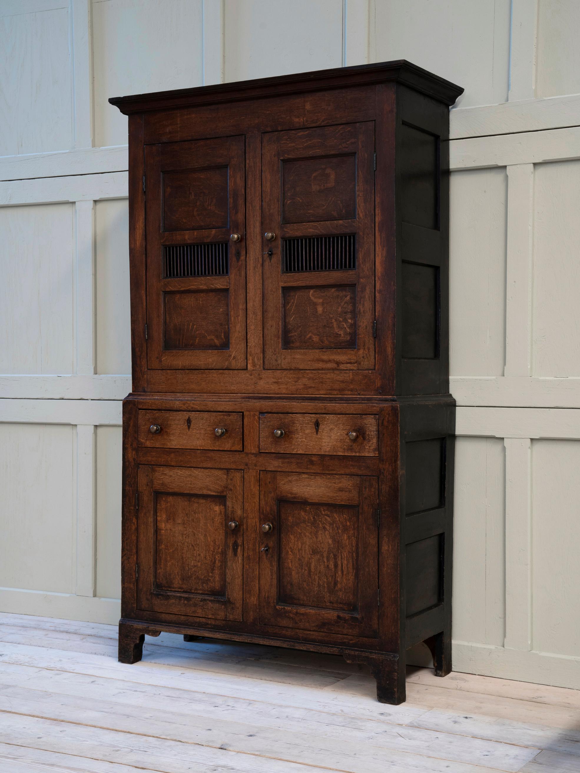 An early 19th century oak and pine “bread and cheese” cupboard, or as they are referred to in Wales a “Cwpwrdd Bara Caws”.

The oak facade with painted pine returns, raised on bracket feet with brass handles.

The most original example we have