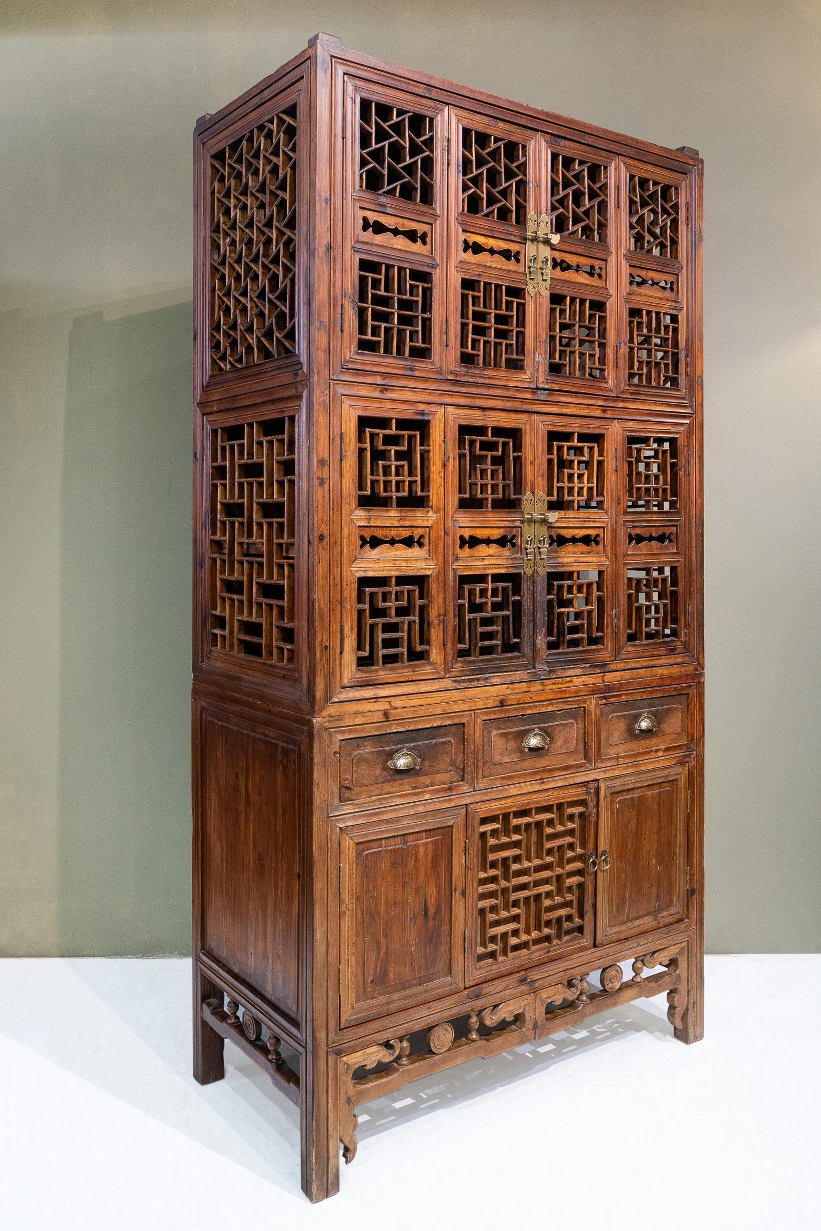 An early 20th century tall kitchen cabinet from Zhejiang province, China. The most interesting part about this cabinet is there are many different lattice patterns on it, right at the top in front and on both sides is the 