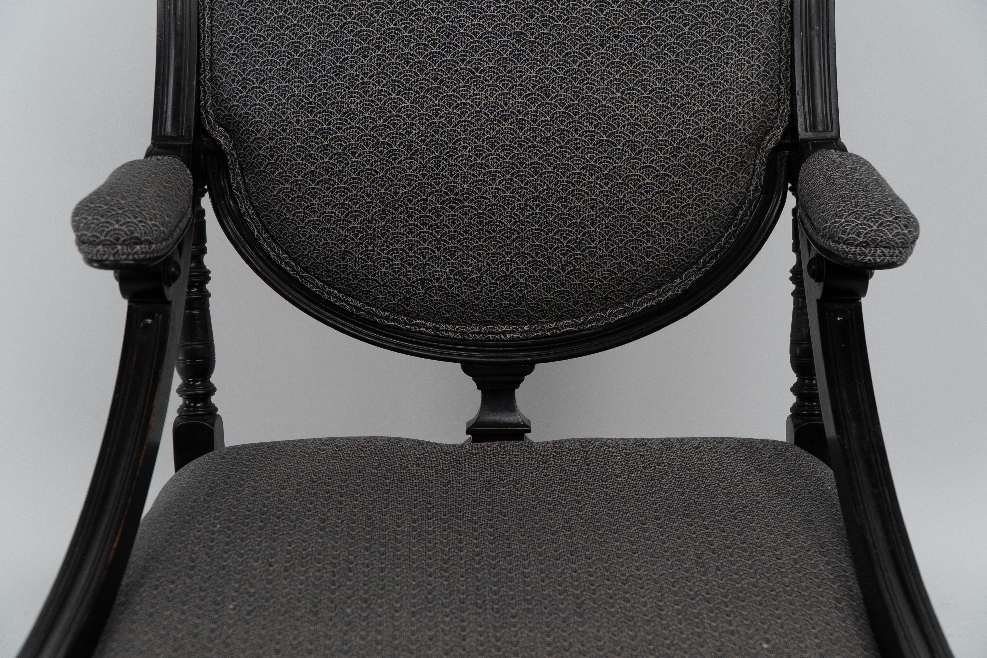 An Aesthetic Movement ebonized & upholstered armchair with sweeping side rails. For Sale 2