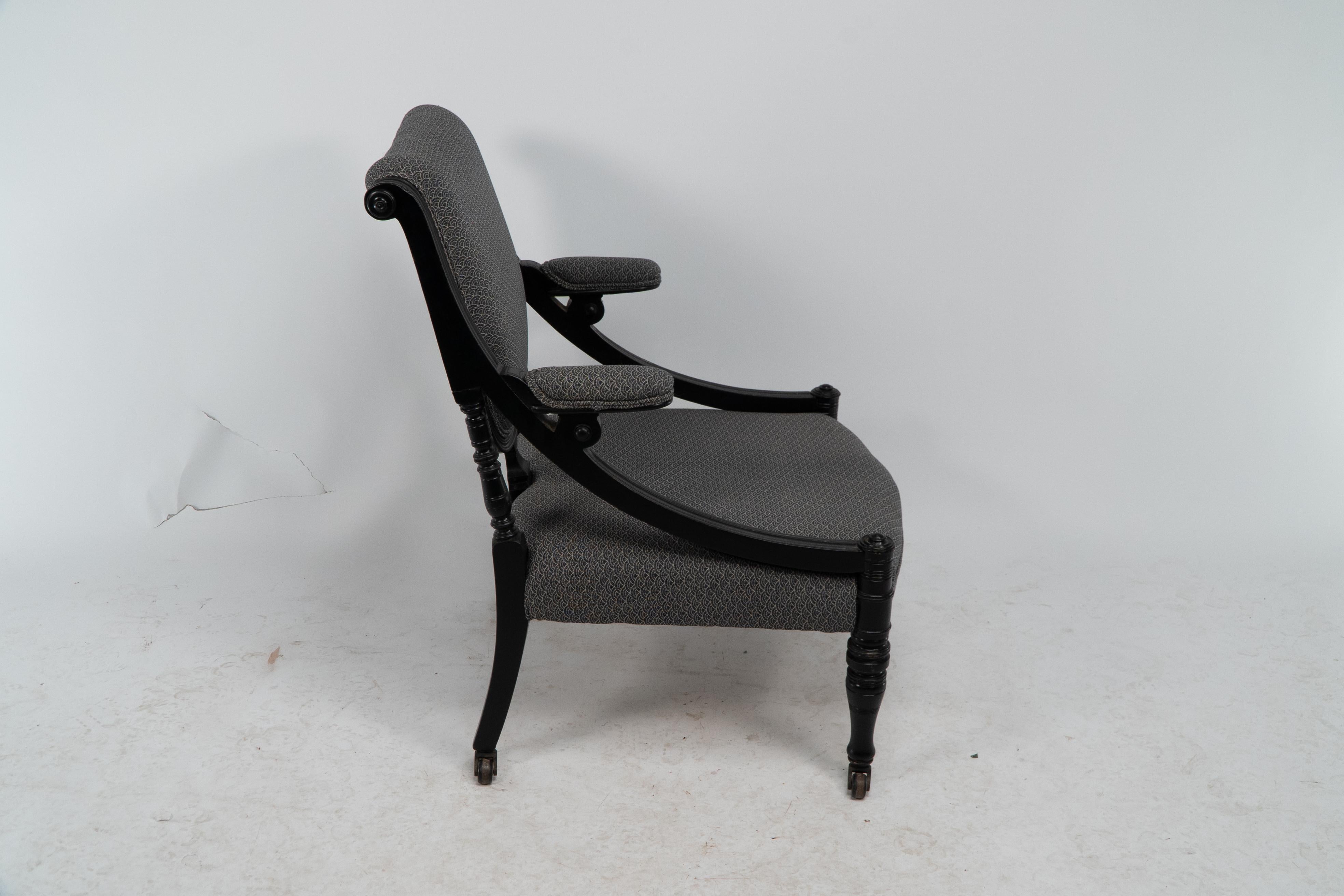 Ebonized An Aesthetic Movement ebonized & upholstered armchair with sweeping side rails. For Sale