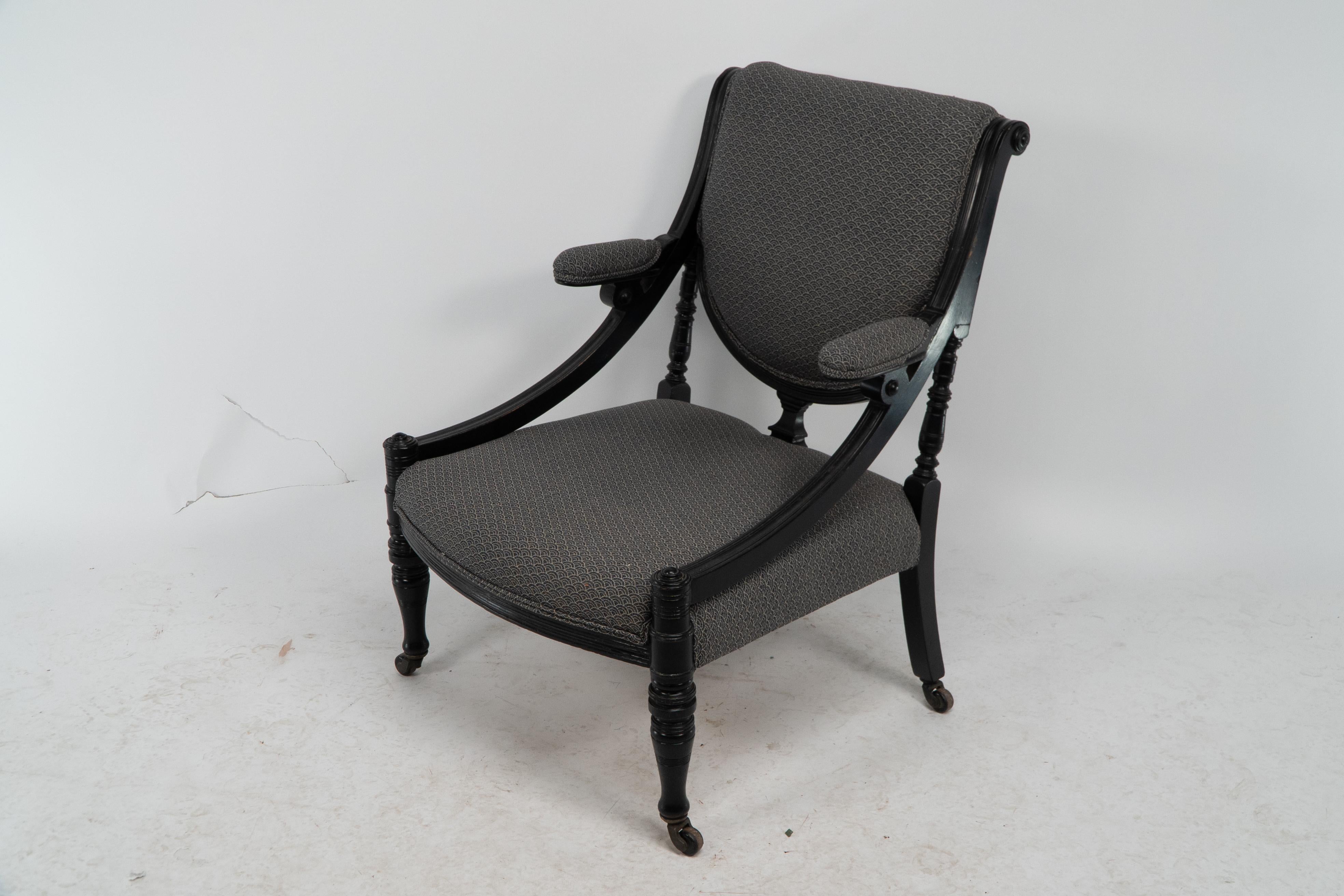 English An Aesthetic Movement ebonized & upholstered armchair with sweeping side rails. For Sale