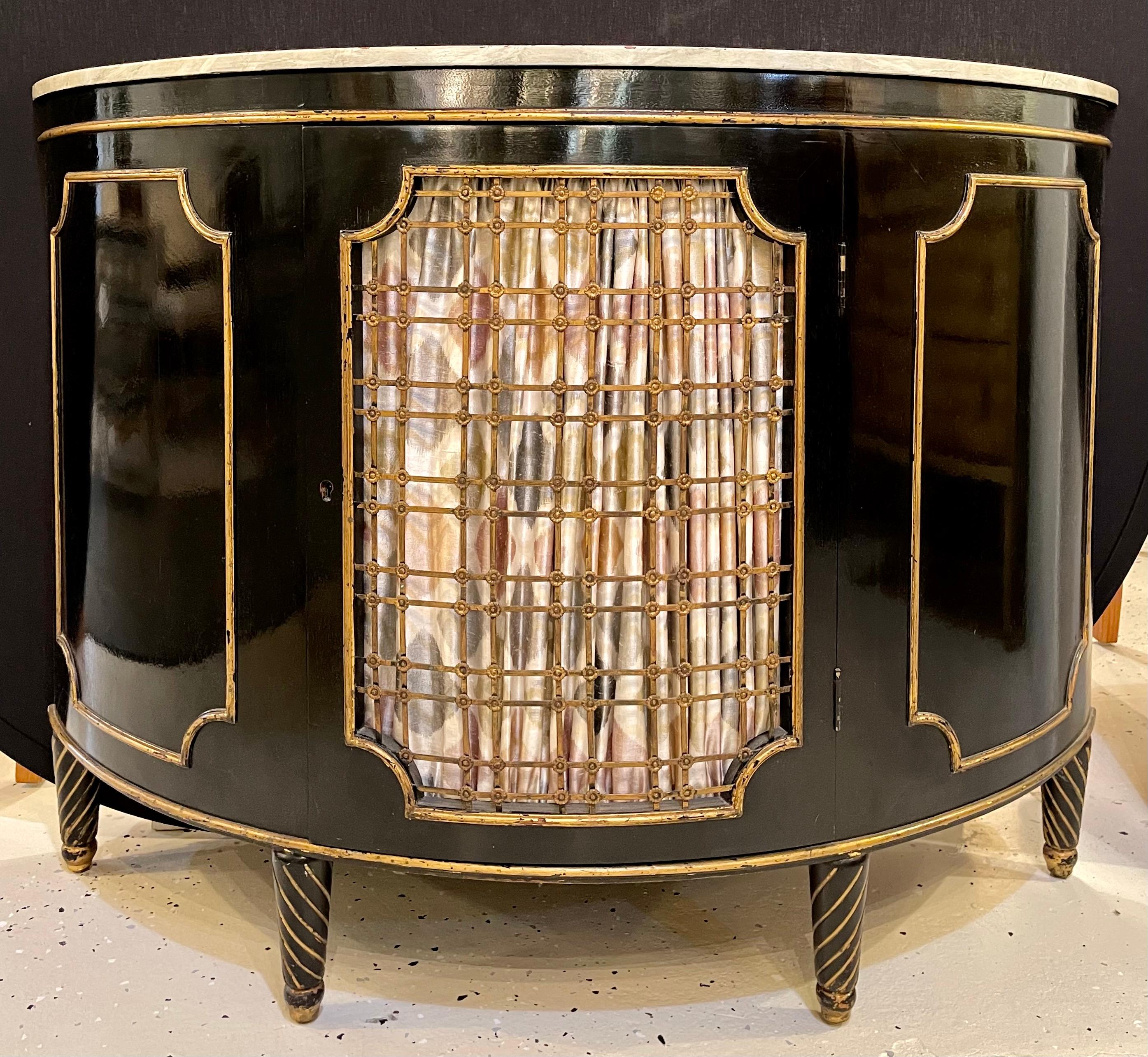 A demilune commode or server gilt gold and bronze decorated, Hollywood Regency style commode, chest or nightstand that is simply stunning. The sleek and clean lines leading to a deep bow front having bronze grilled door front opening to a shelved
