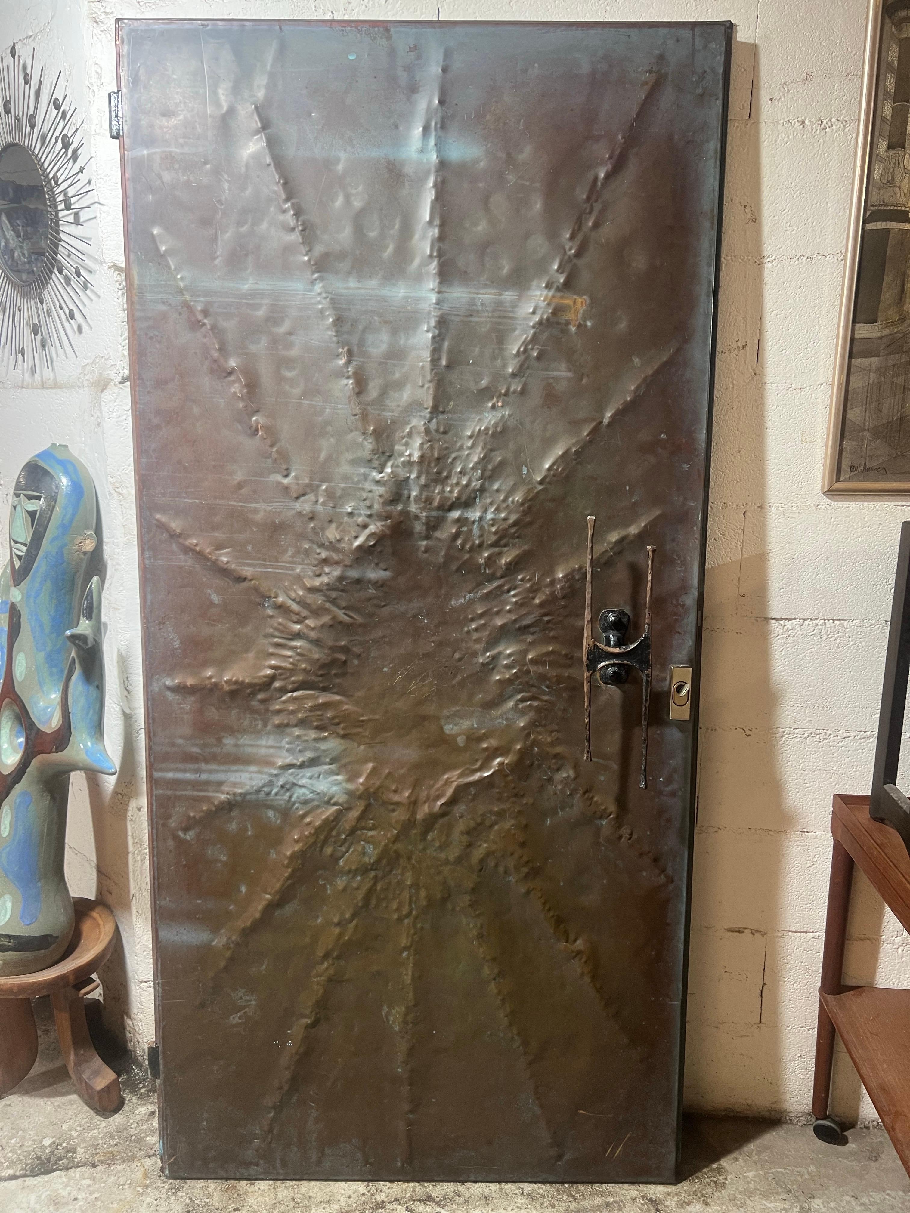 Une porte inhabituelle en cuivre avec une poignée exceptionnelle et une double face en cuivre sur les deux côtés.