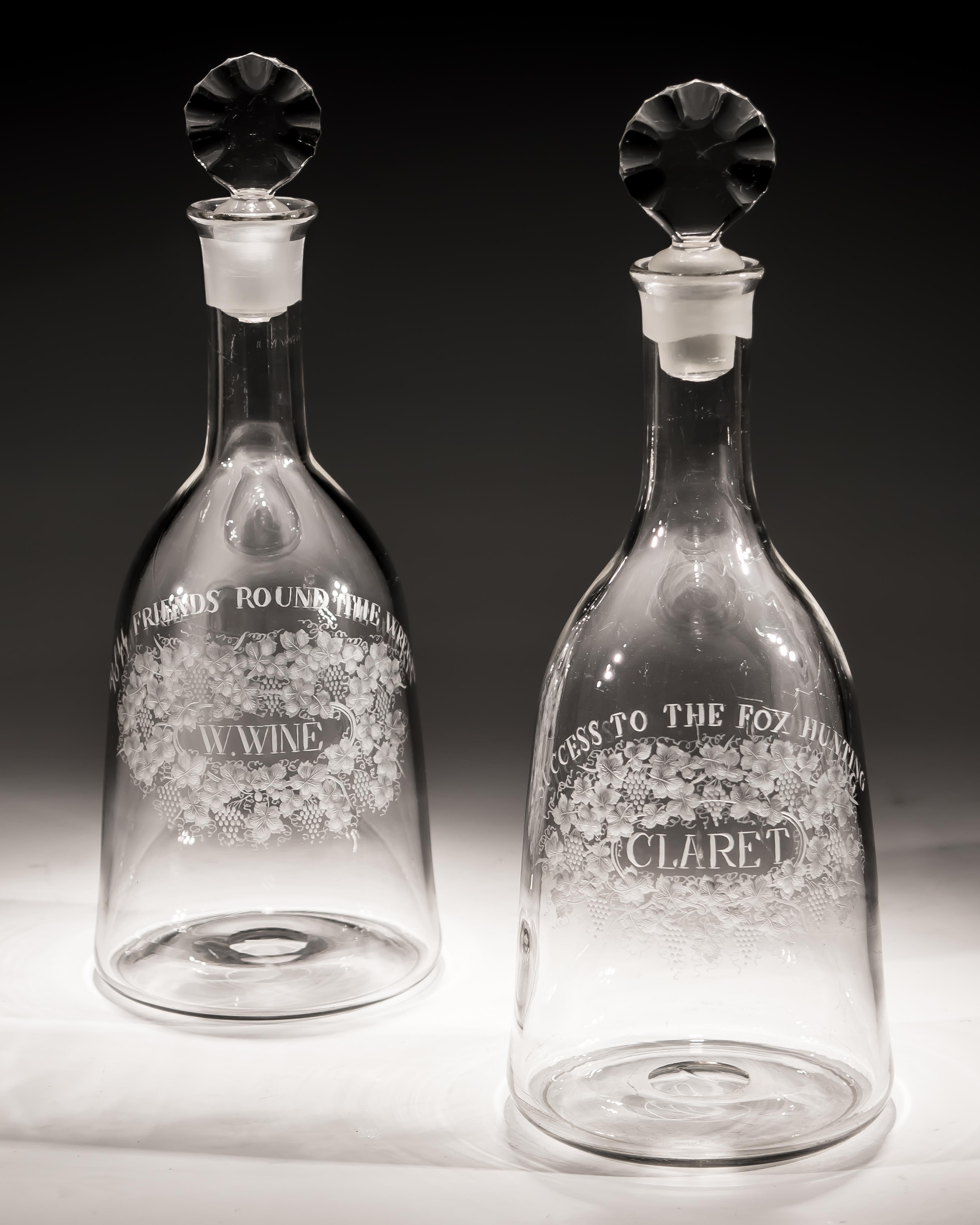A pair of mallet decanters finely engraved with 'w.wine' & 'claret' labels surrounded with fruit and vines with titles 'Success to the fox hunting' & 'To all friends round the wrekin'.