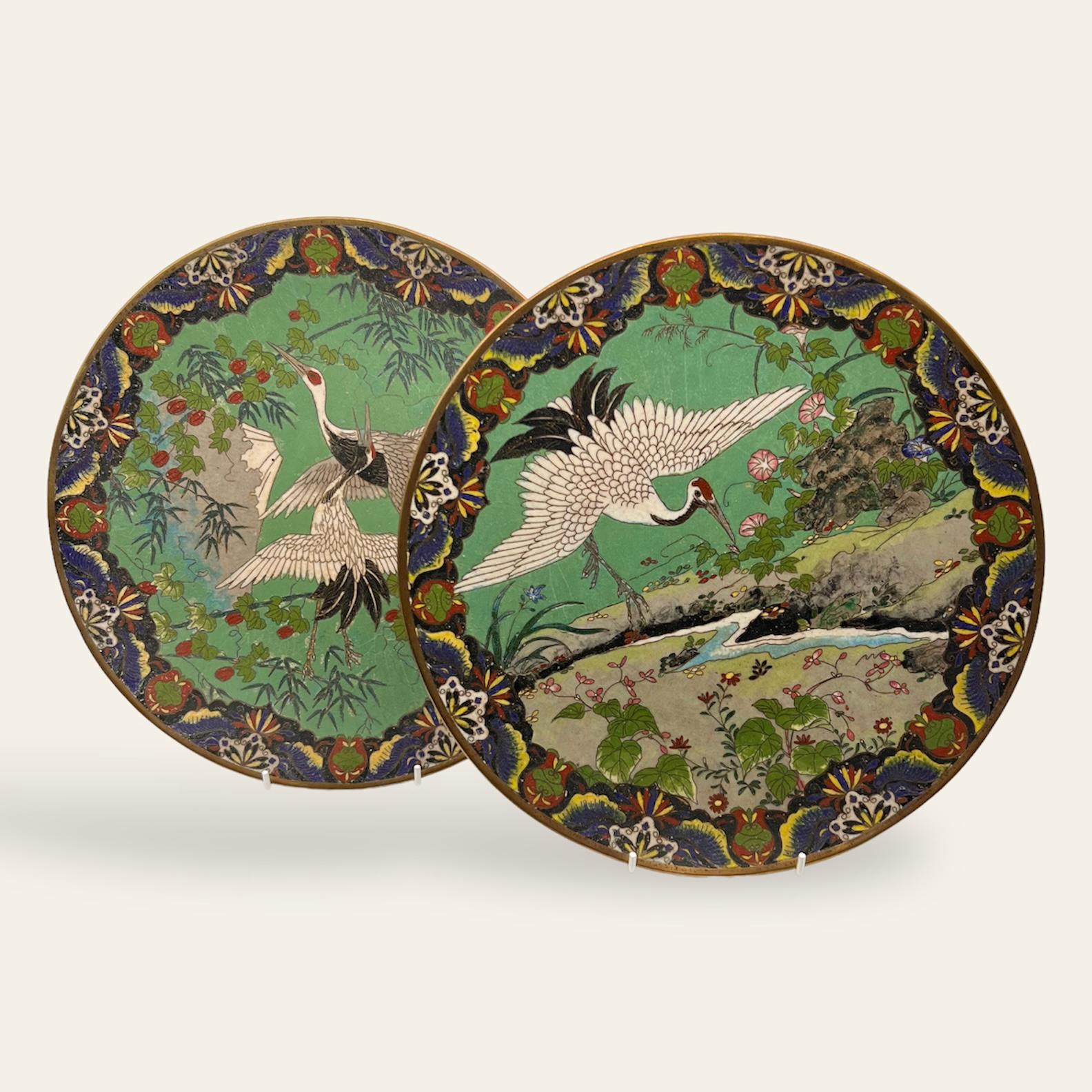 A 19th C exquisite and highly decorative pair of Japanese Cloisonne chargers in rare imperial emerald green background to frame a beautiful white cranes amongst pink and red flowers , vines and foliage. Vary auspicious with a detailed pattern around