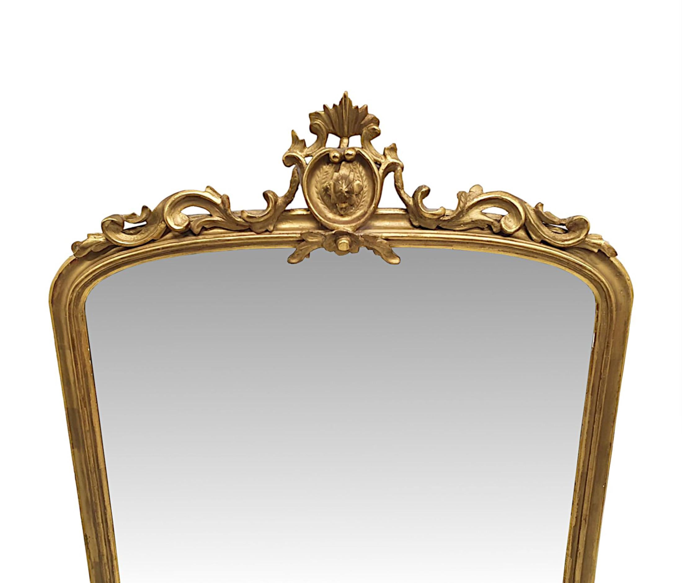 A fabulous 19th century giltwood overmantle mirror. The mirror glass plate of arch top form is set within a stunningly hand carved, moulded and pierced giltwood frame, surmounted with an elegantly ornate, centred crest composition comprising of