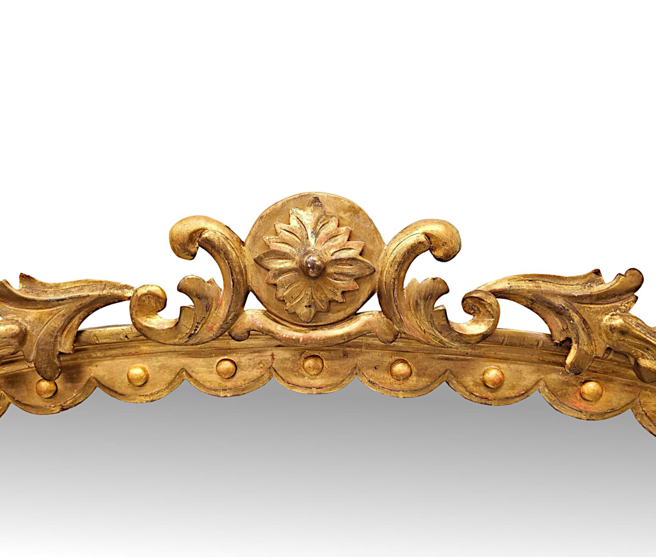 A fabulous 19th Century giltwood overmantel mirror, finely hand carved and of exceptional quality.  The mirror glass plate of shaped rectangular form is set within a stunning pierced, moulded and fluted giltwood frame with pilaster columns to the