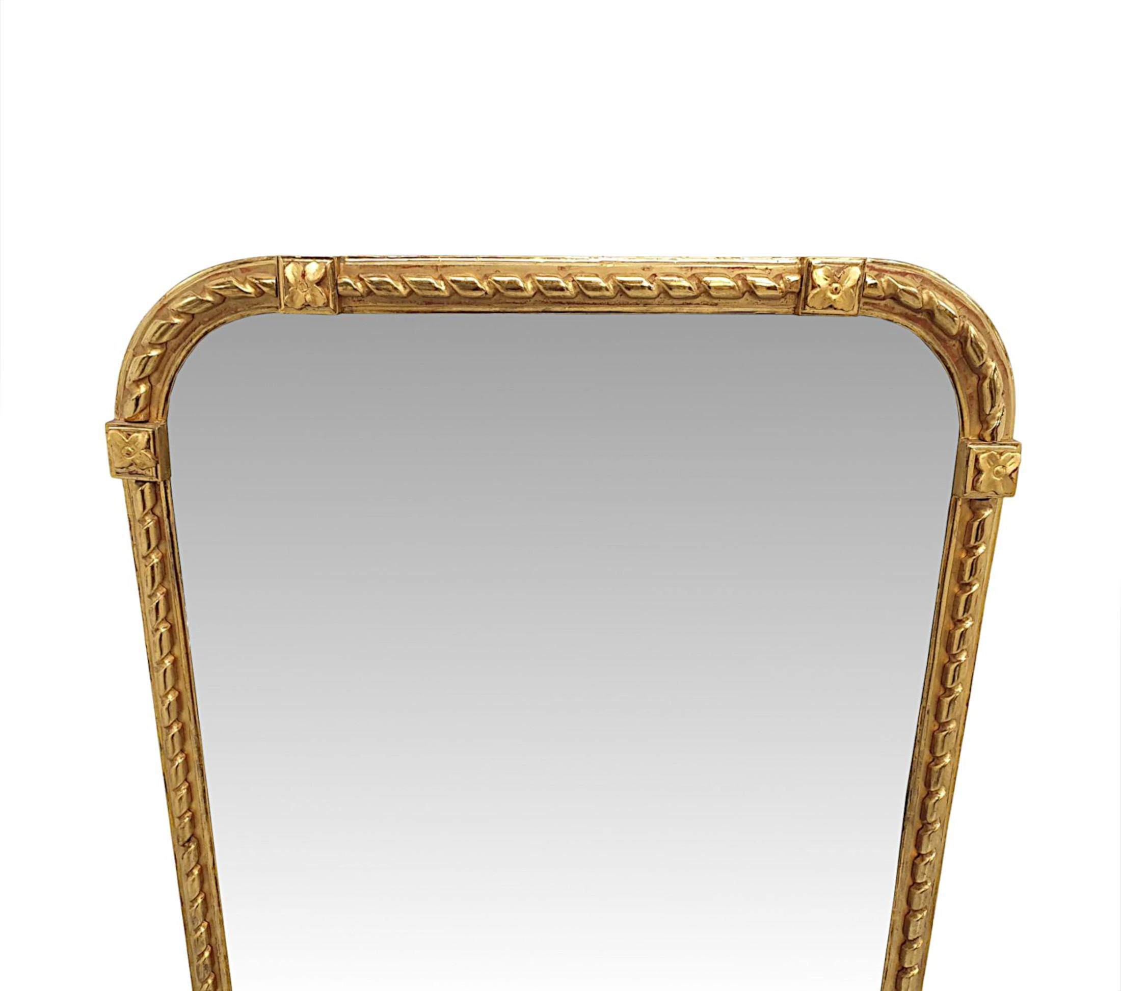 Un fabuleux miroir de manteau du 19e siècle, finement sculpté à la main et d'une qualité exceptionnelle.  La plaque de verre miroir de forme arquée est enchâssée dans un élégant cadre en bois doré mouluré et cannelé, orné d'un magnifique ruban