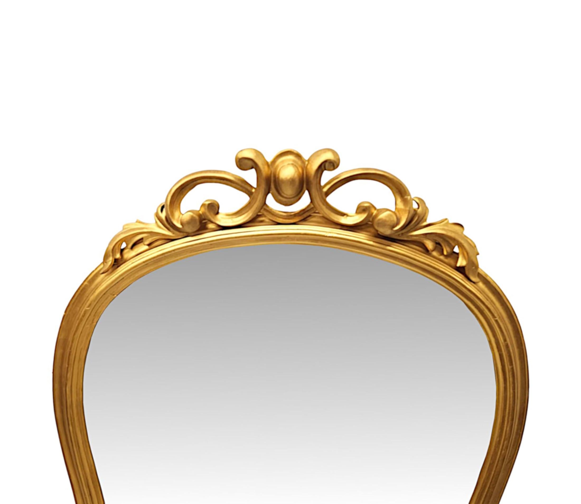 Un favoloso specchio ad arco in legno dorato del XIX secolo, di forma allungata e di qualità eccezionale.  La lastra di vetro a specchio sagomata è incastonata in una cornice in legno dorato finemente intagliata a mano, modellata, scanalata e