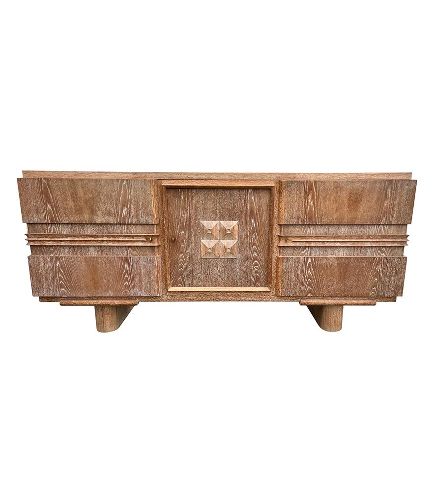 A fabulous Art Deco limed oak three doored sideboard by Francisque Chaleyssin with geometric centre panel and orignal locks and brass keys, mounted on plinth feet. A stunning quality timeless piece, in great orignal condition with amazing patina