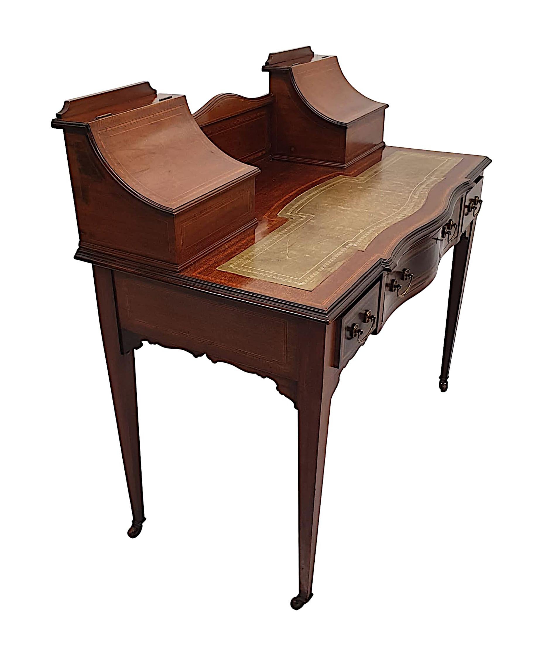 A fabulous Edwardian mahogany desk in the Carlton house style, finely carved, line inlaid and cross banded throughout and of gorgeous quality with rich patination and fine grain. The moulded and shaped upper section flanked with a pair of concave,