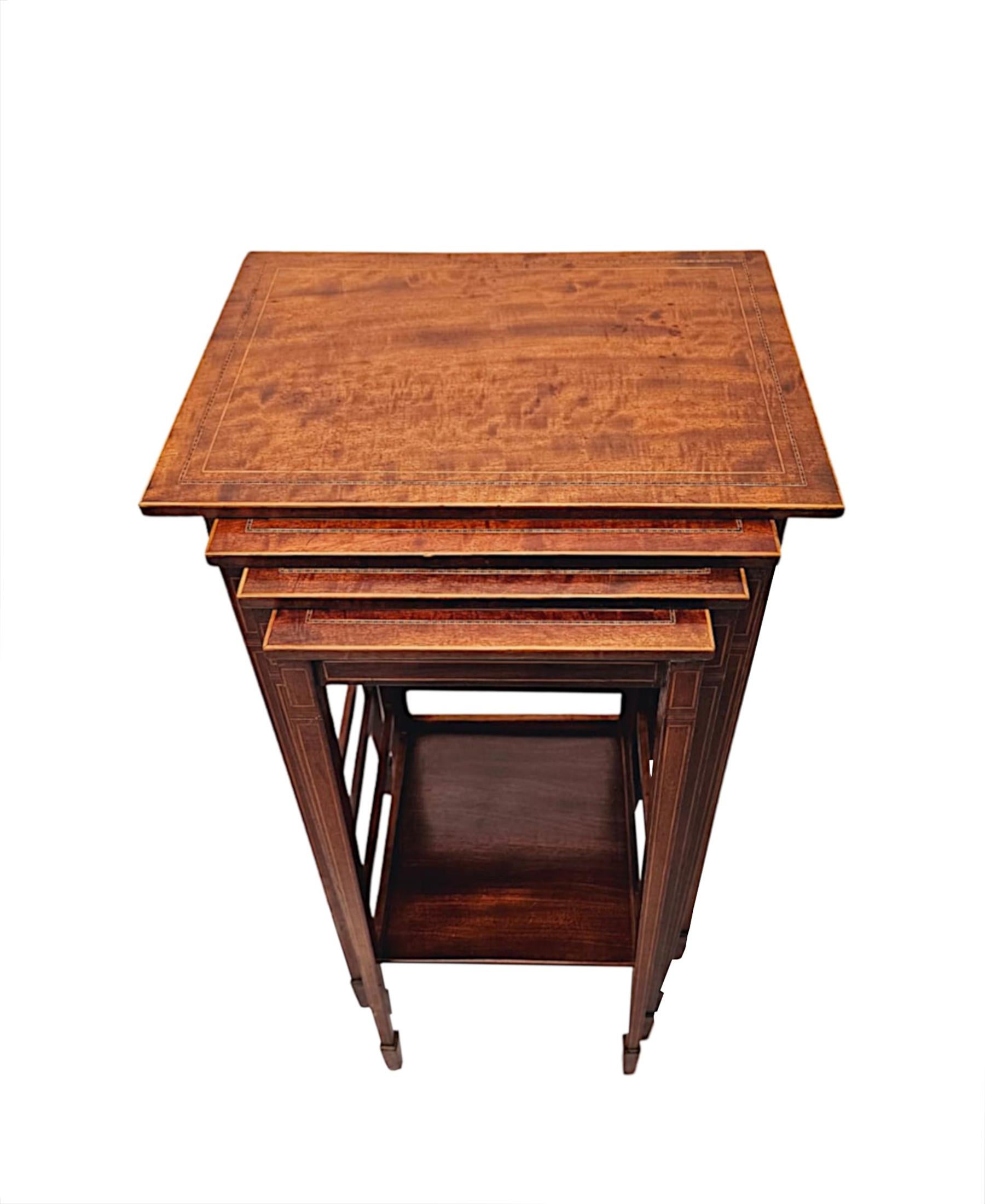 A fabulous Edwardian inlaid mahogany nest of four tables of exceptional quality and finely carved with stunningly rich patination and grain.  The well figured, moulded top of rectangular form features gorgeous line inlay and marquetry border panels,