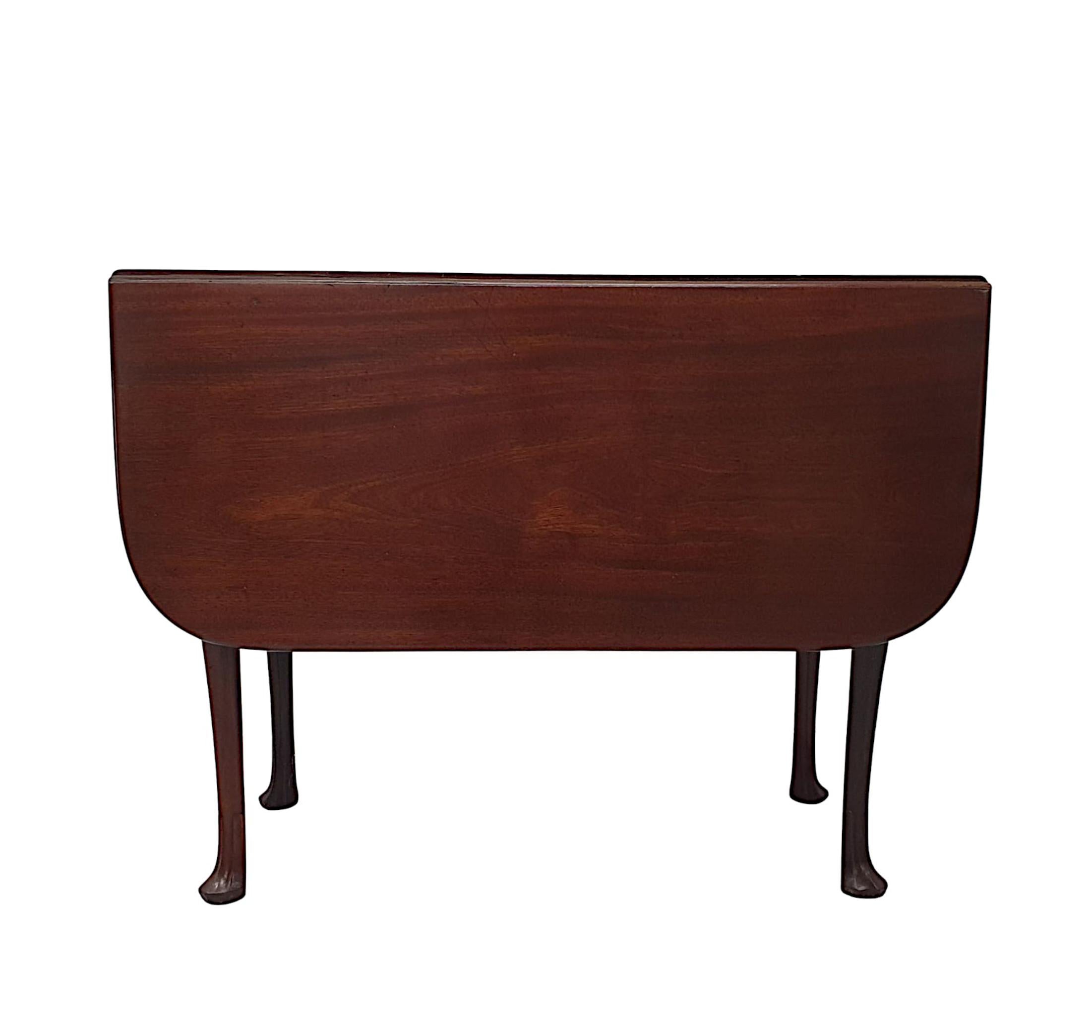 A fabulous quality Georgian Irish mahogany drop leaf table with rich patination and grain. The attractive, well figured, shaped and moulded top of rectangular form with two twin hinged drop leaves to either side raised over a simple and shaped