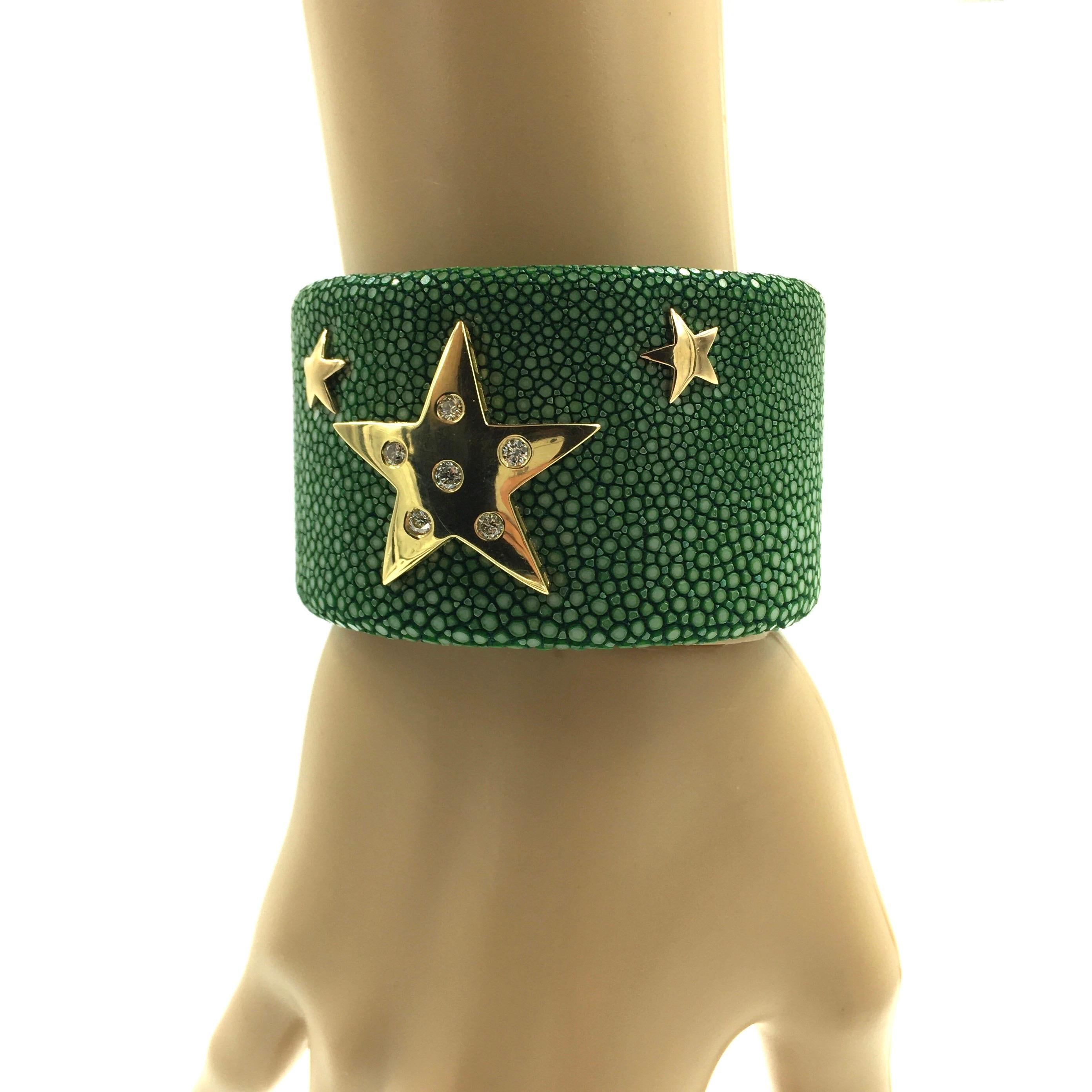 A 40mm wide forest green color shagreen covered cuff, set with a five-point 14 karat yellow gold star, which has been set with six round brilliant cut diamonds, and set with two small five-point 14 karat yellow gold stars.