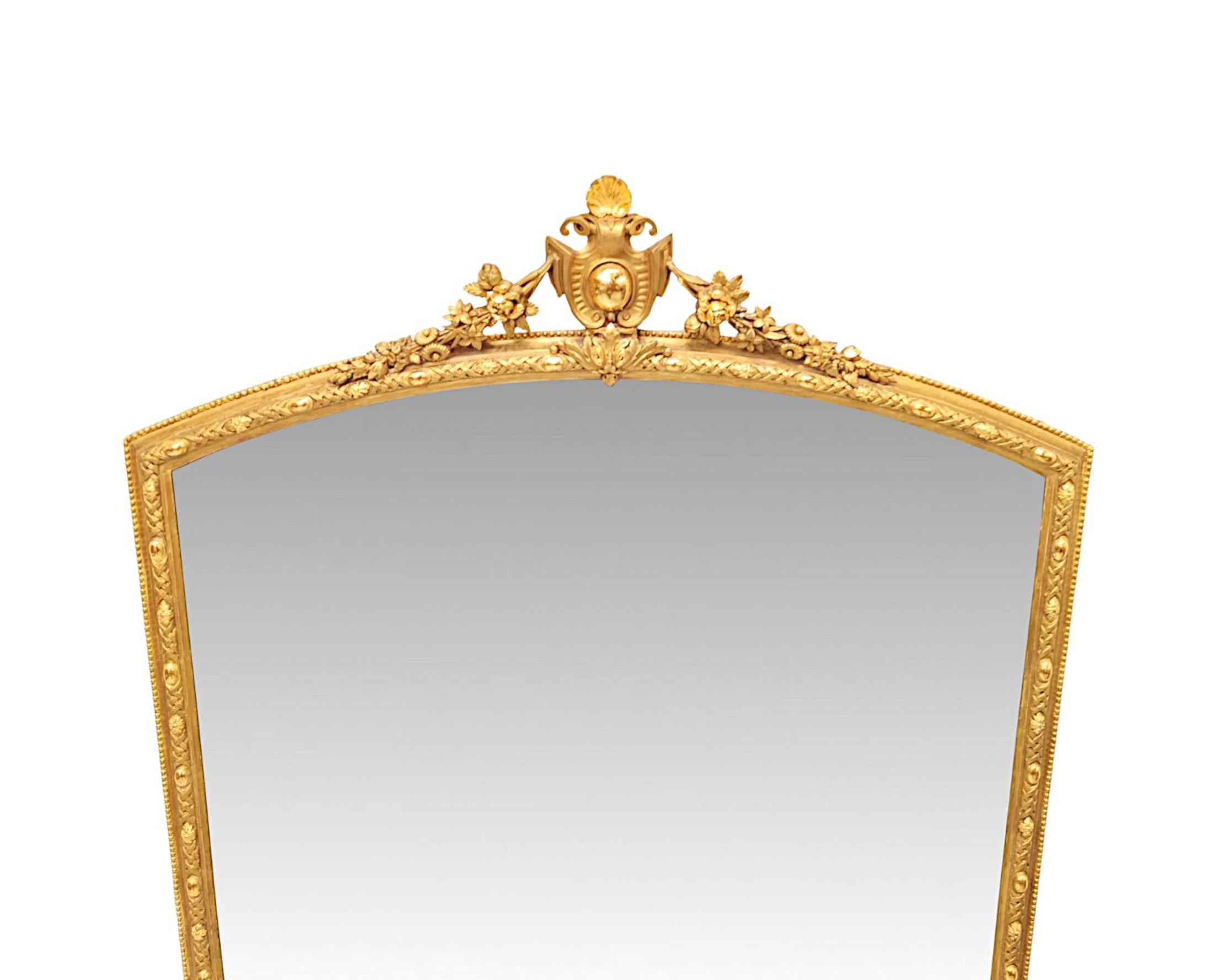 Un fabuleux miroir à trumeau en bois doré du XIXe siècle, d'une qualité exceptionnelle et de grandes proportions.  La plaque de verre miroir est enchâssée dans un cadre en bois doré finement sculpté à la main, cannelé et percé, avec d'élégants