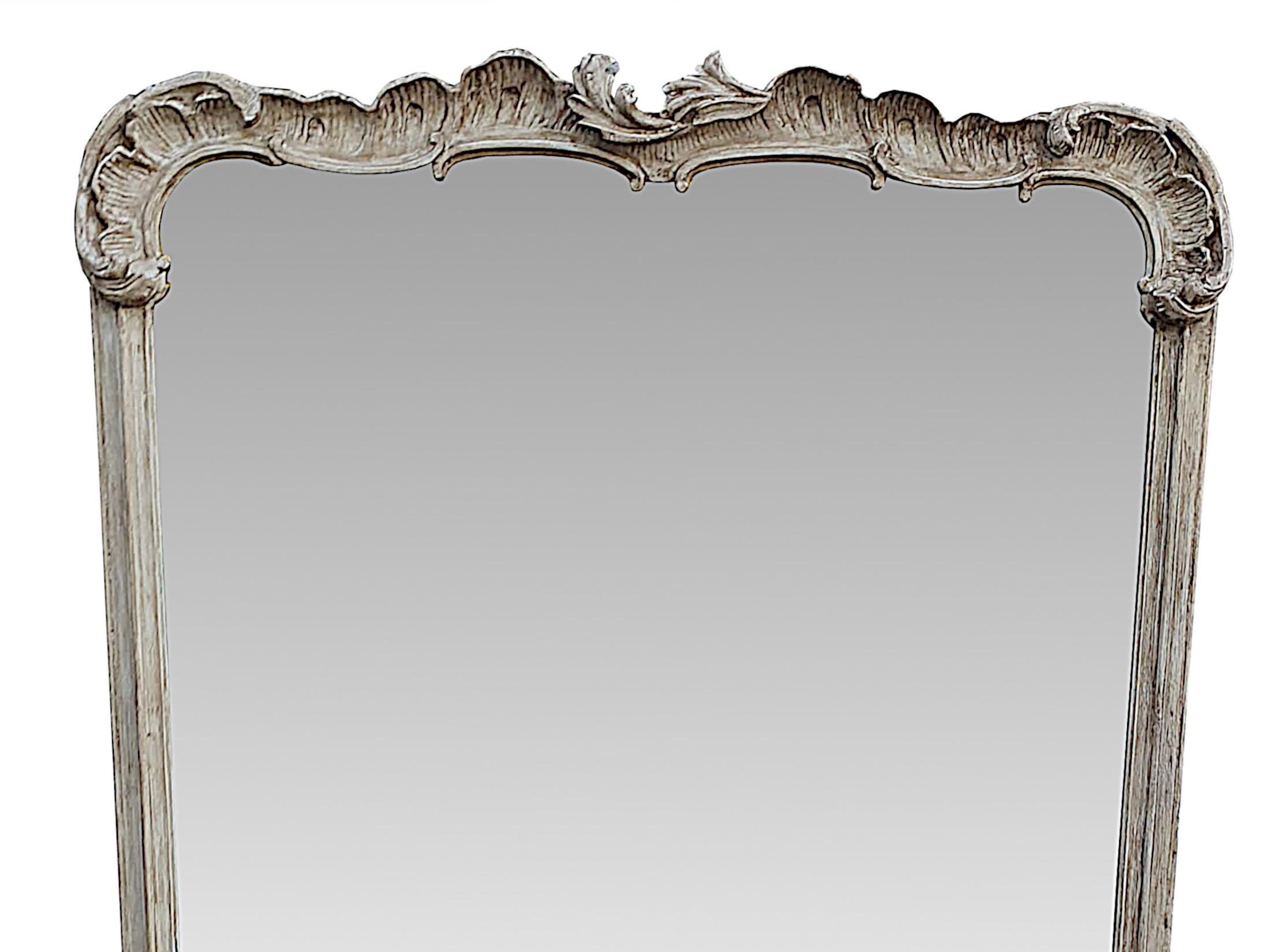 A fabulous large early 19th century overmantle mirror with a gorgeous, distressed painted finish. The mirror glass plate of rectangular form is set within a hand carved frame surmounted with beautifully detailed c scrolls and ruffles with centred