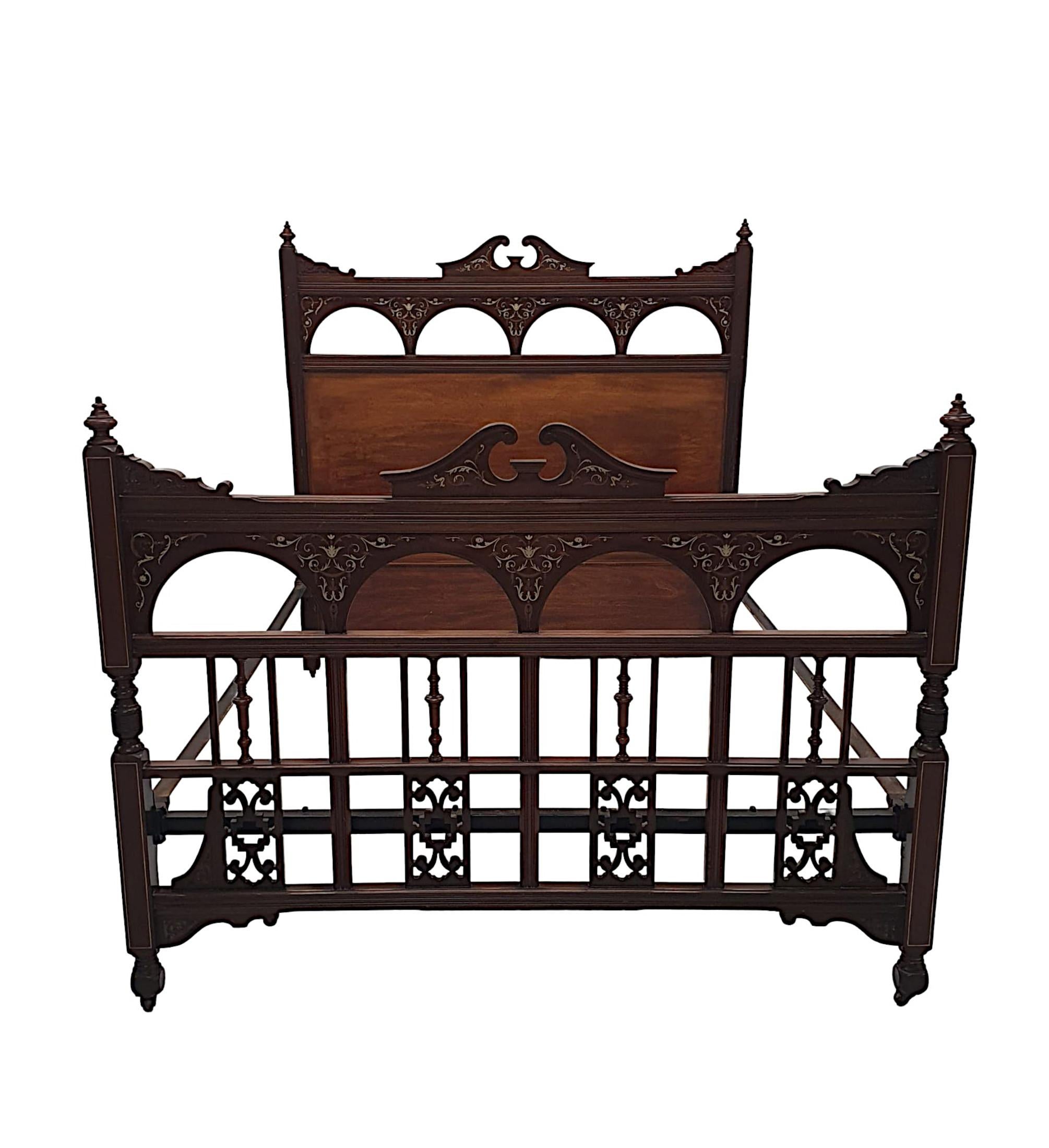 A fabulous late 19th Century inlaid mahogany five foot wide bed, finely hand carved, richly patinated and inlaid with stunning detail throughout. The moulded foot and headboard both feature a centred broken swan neck pediment flanked with carved