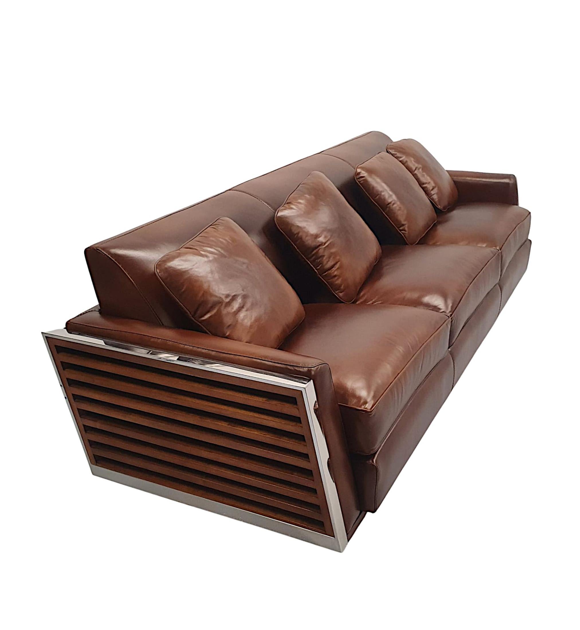 A fabulous three seater leather and chrome framed contemporary sofa in the Art Deco style, of gorgeous quality and beautifully unholstered in elegant brown leather with matching cushions, set within a stunning pierced chrome frame, supported on