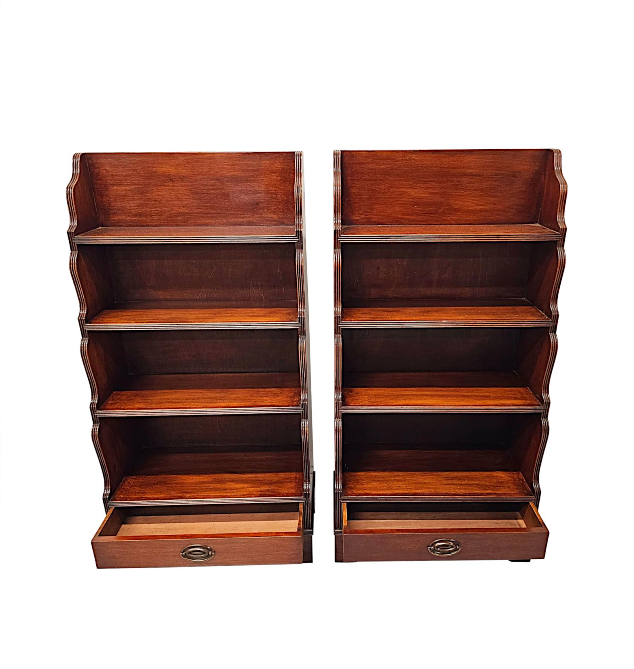 Una favolosa coppia di librerie a cascata in mogano di epoca edoardiana, finemente intagliate, di proporzioni ordinate e con una patina e una venatura molto ricca.  I quattro ripiani graduati modanati sono incastonati in splendidi sostegni laterali