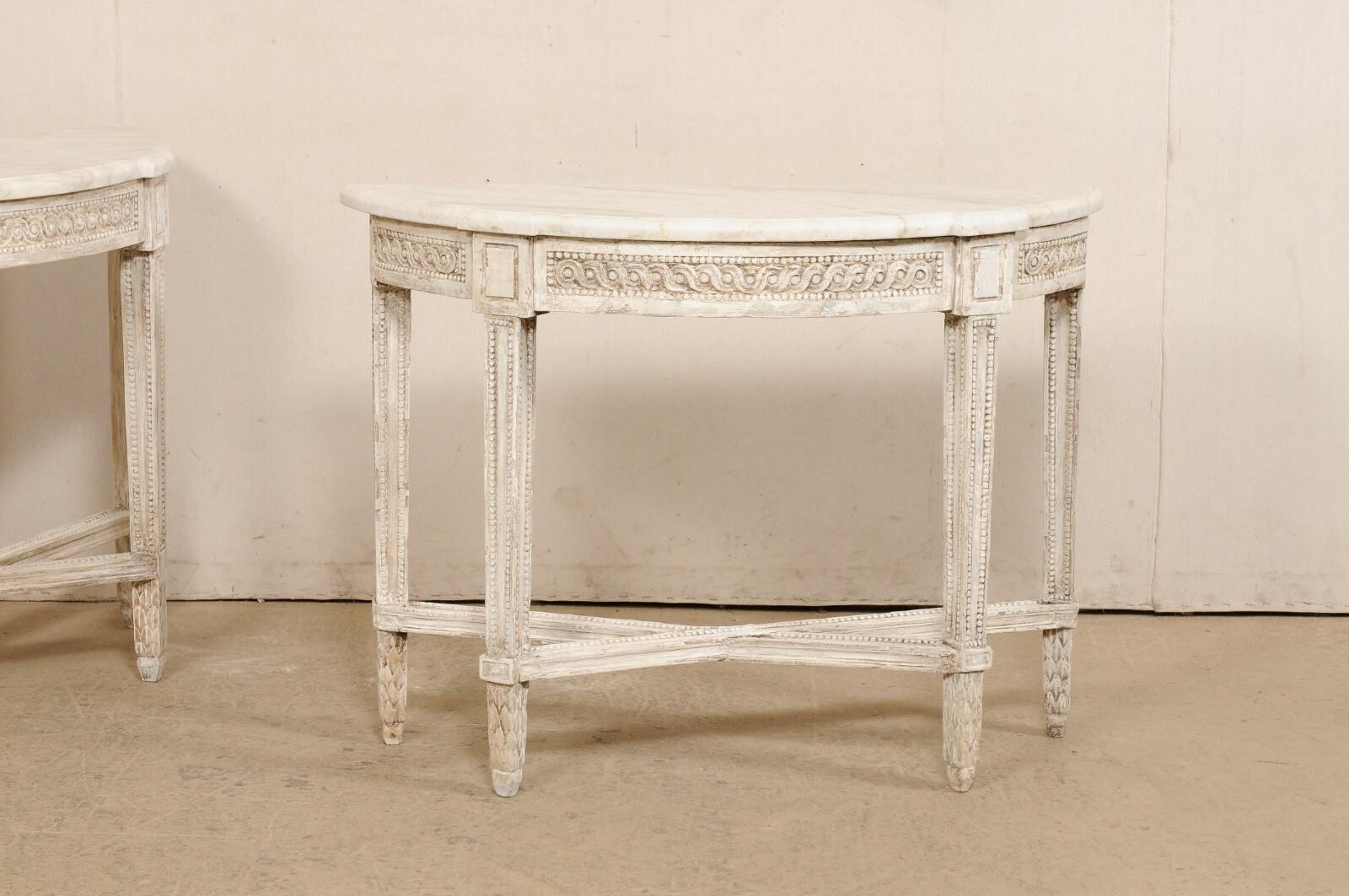 An Italian pair of nicely carved demi lune tables with quartzite tops from the 18th century. This pair of console tables from Italy are adorn in fabulously detailed carvings; with petite bead trim outlining the apron, legs, & stretchers. A carved