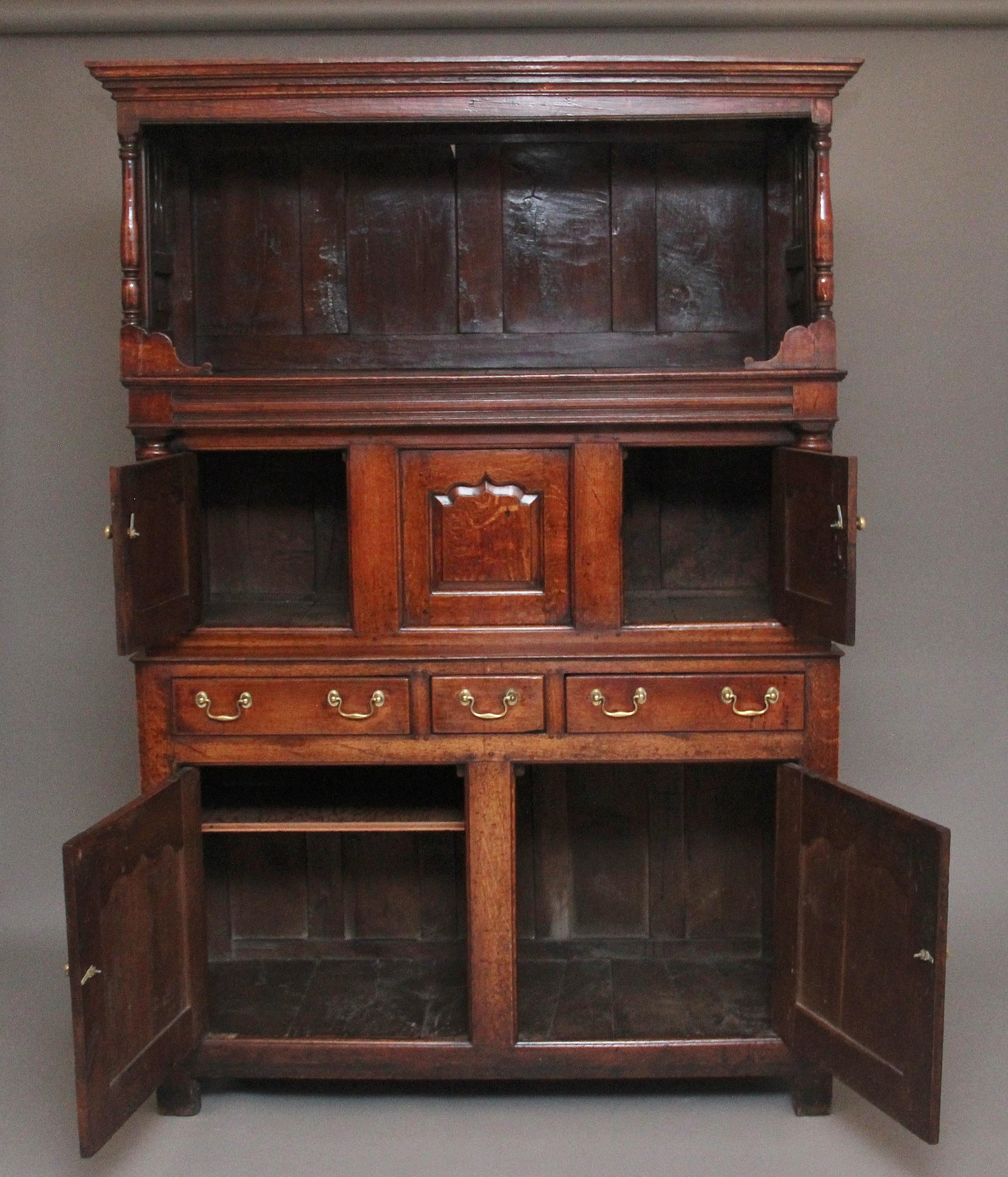 An exceptional antique Mid-18th Century cwpwrdd tridarn (court cupboard) The tridarn consists of an open section to the top for the display of their copper, brass and pewter, the middle section has two fielded doors and a fielded panel in the centre