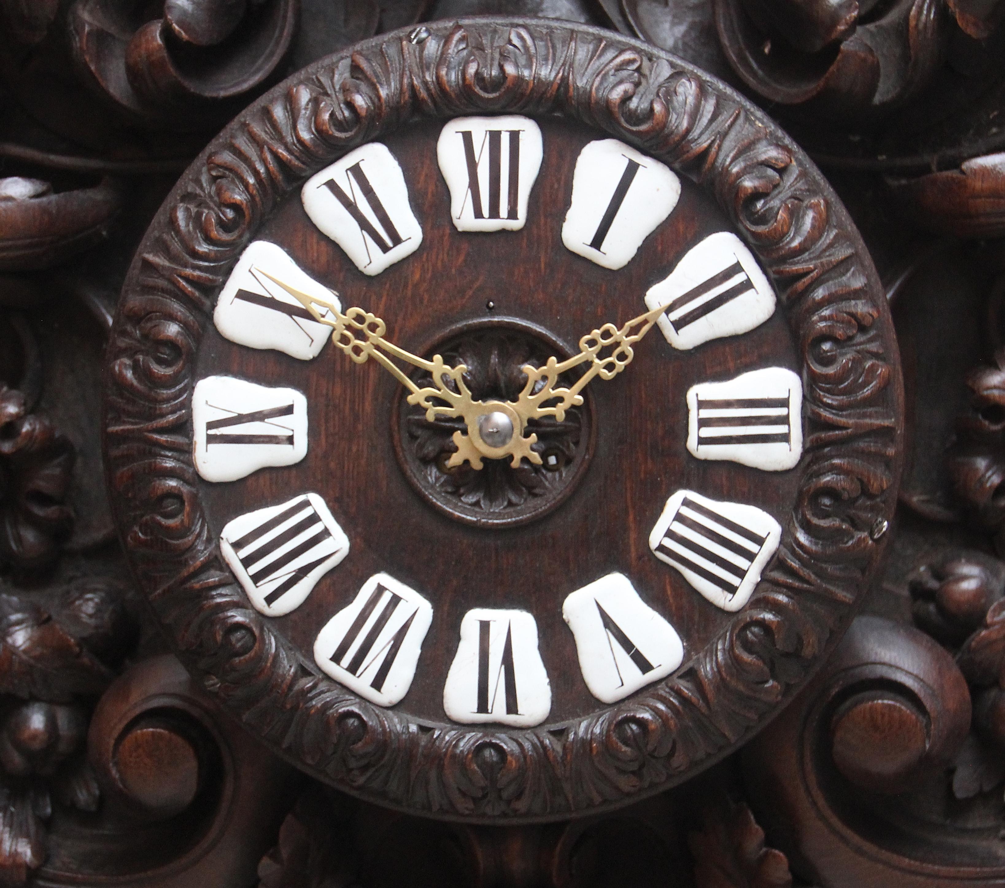 Une fabuleuse horloge murale en chêne sculpté français du 19ème siècle, le cadran circulaire de l'horloge situé au centre avec un bord décoratif sculpté et mouluré,  Autour du cadran de l'horloge se trouve une plaque abondamment sculptée de divers