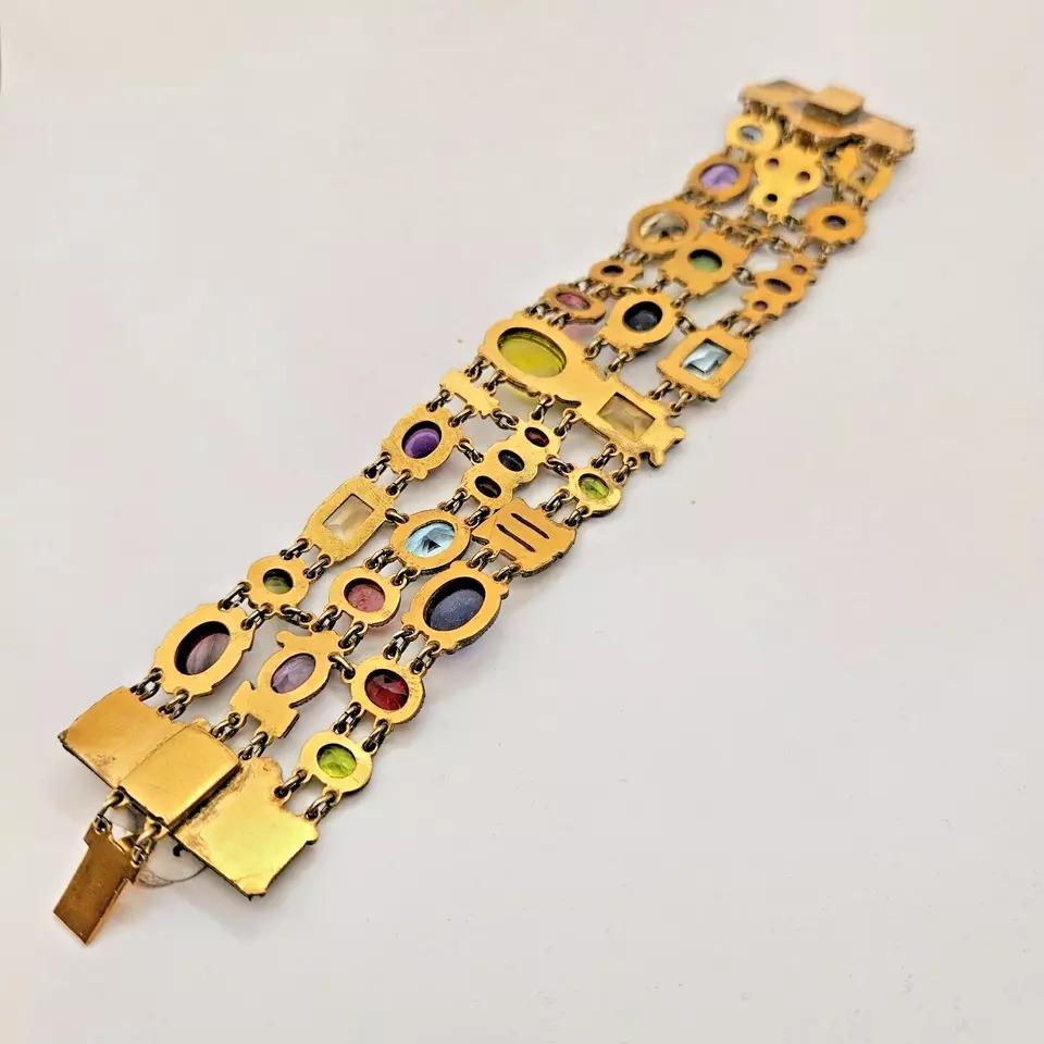 This is an exquisite vintage bracelet that is sure to catch the eye of any jewellery enthusiast. The piece features a stunning mix of gemstones and cloisonne enamel, all set in a heavy gauge yellow gold plate. 
Made using the Cloisonne Enamel