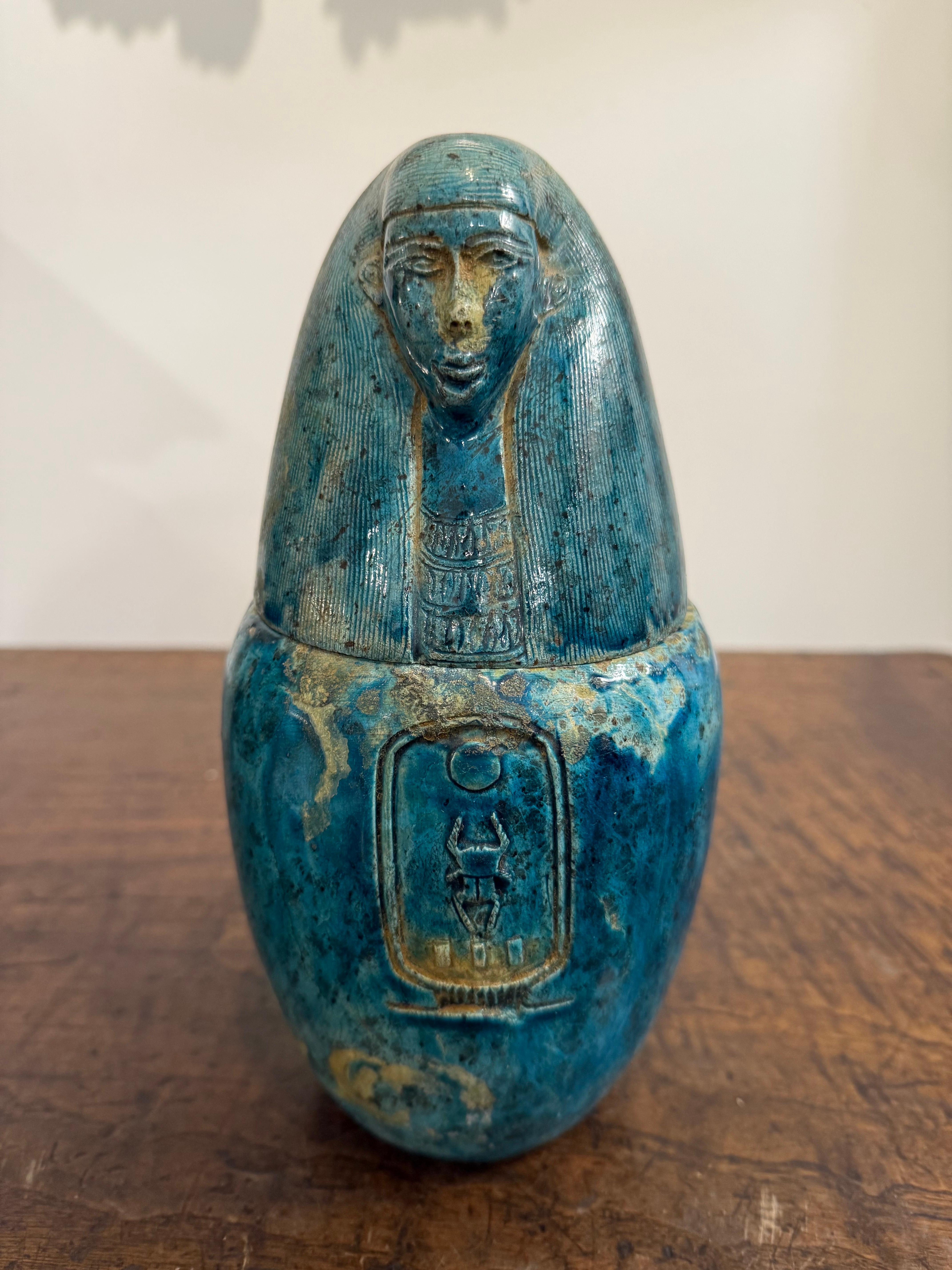 A Faience Glazed Ceramic Canopic Jar of Imsety, Early 20th Century

Provenance: Private Australian Collection.

Description:
The sturdy ovoid jar with mottled faience glaze throughout, the lid in the form of a human head wearing a nemes, the striped