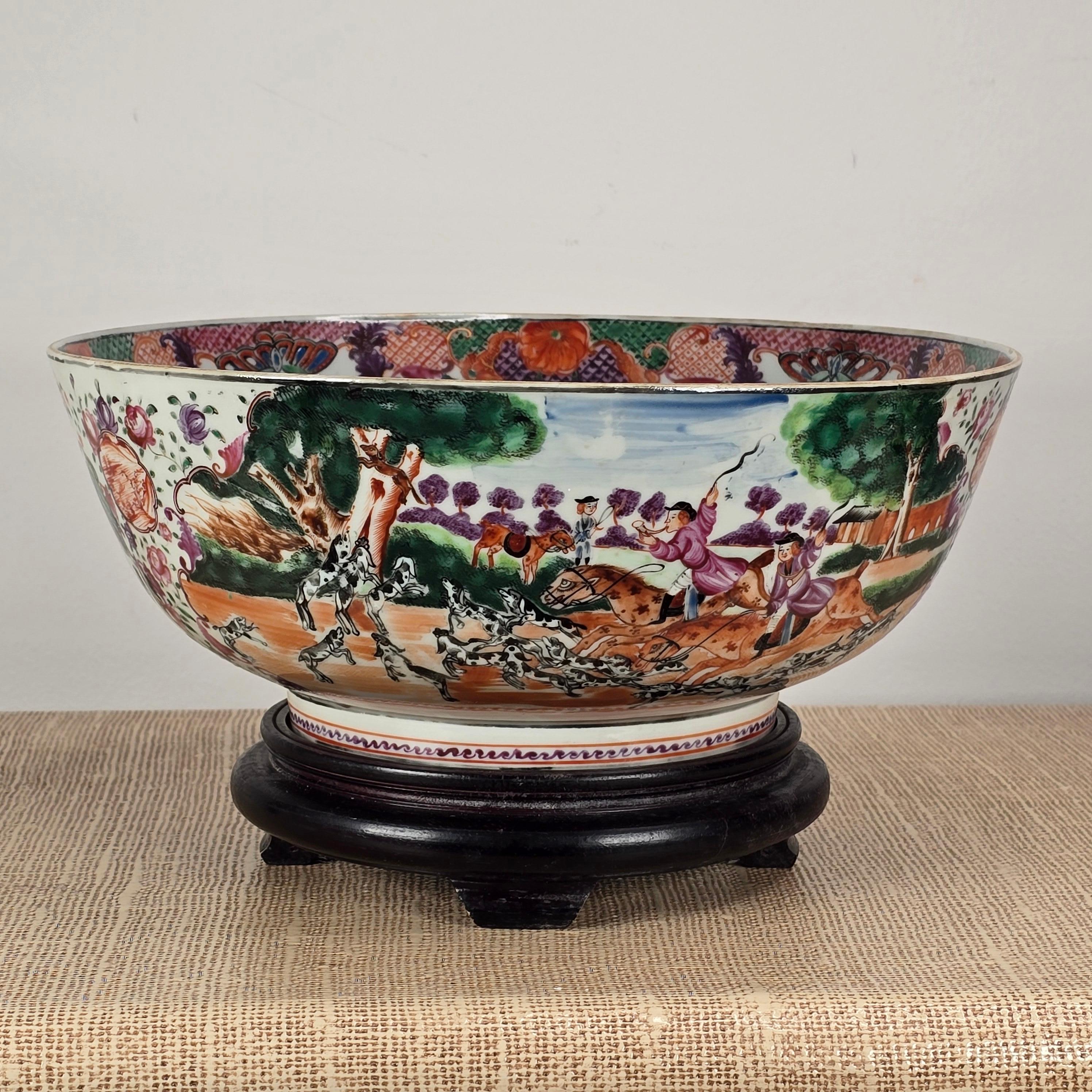 A superb Chinese Export porcelain 'famille-rose' hunt motif punch bowl.  Qing Dynasty, Qianlong period(1735-1795) painted with two large landscape cartouches with Hunting scenes, the interior with a large central roundel of a sportsman accompanied