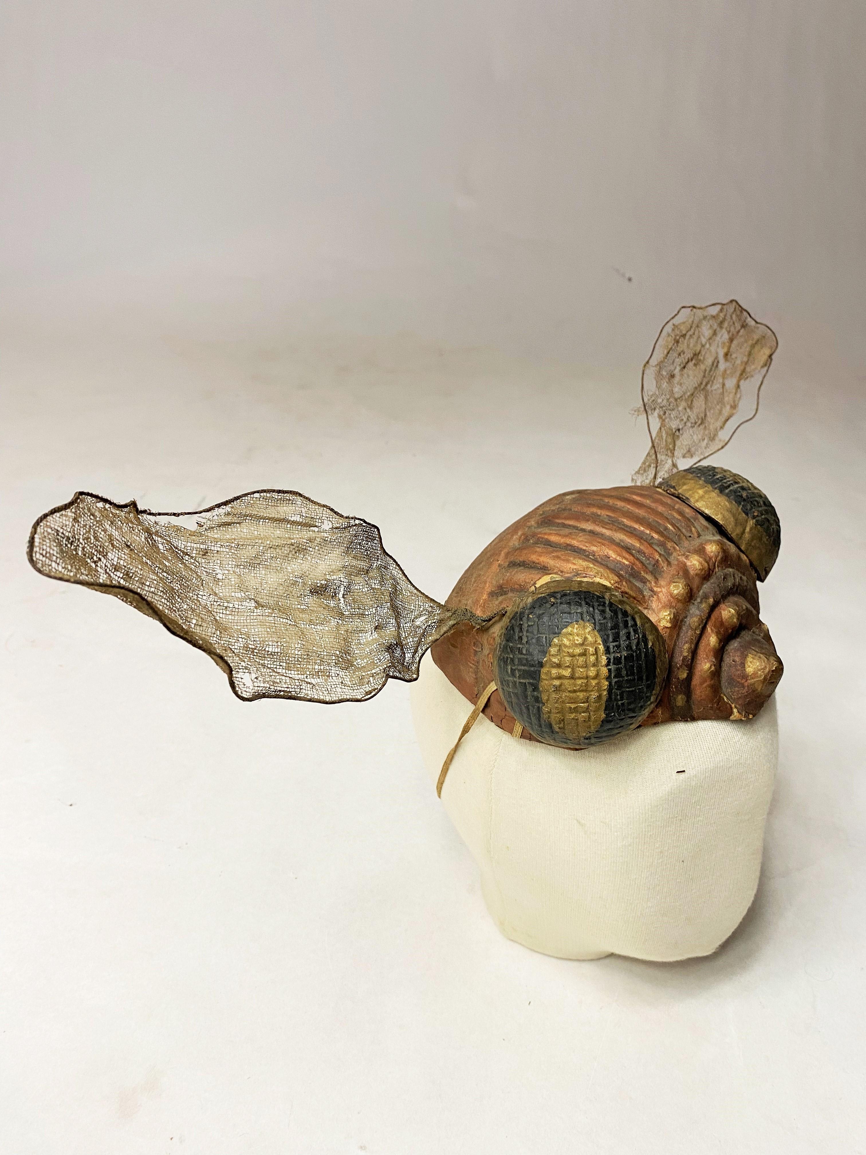 First third of the 20th century
France
A Fancy or Catherinette's Bibi representing a dragonfly head with its wings! Structure in copper, gold and black painted paper mâché, with half-spheres glued on for the eyes. Wings with a wire frame applied