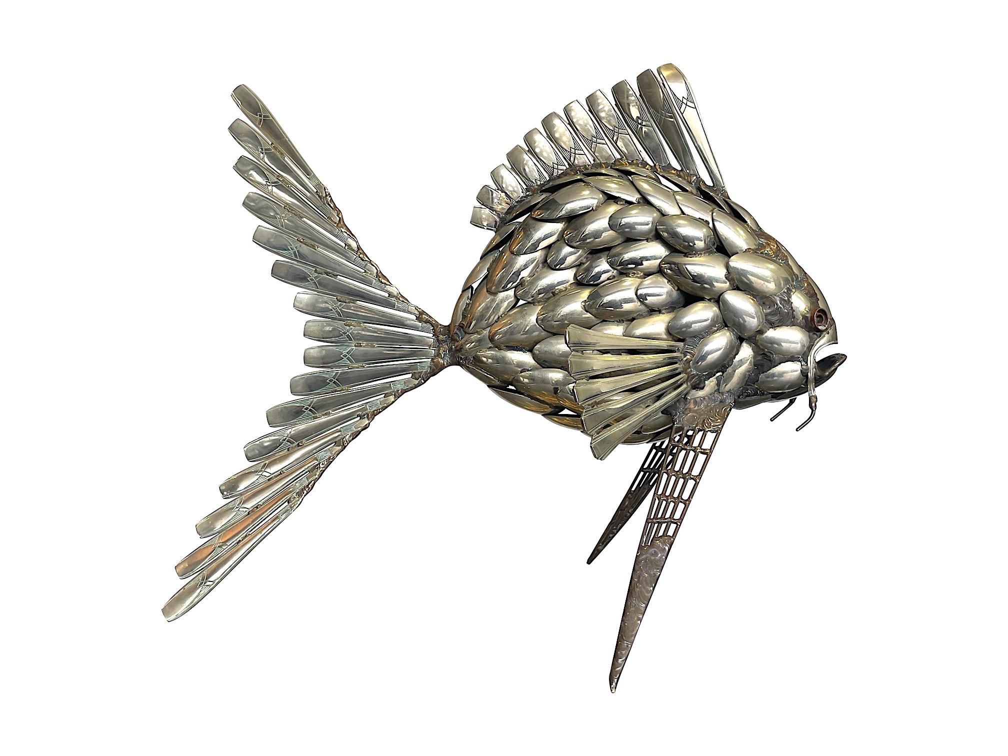 A fantastic large 1950s sculpture of a carp like fish made from silver plated spoons. The bowls of the spoons making up the scales and the handles making up the fins and other detail. The craftsmanship and detail is exceptional with each piece