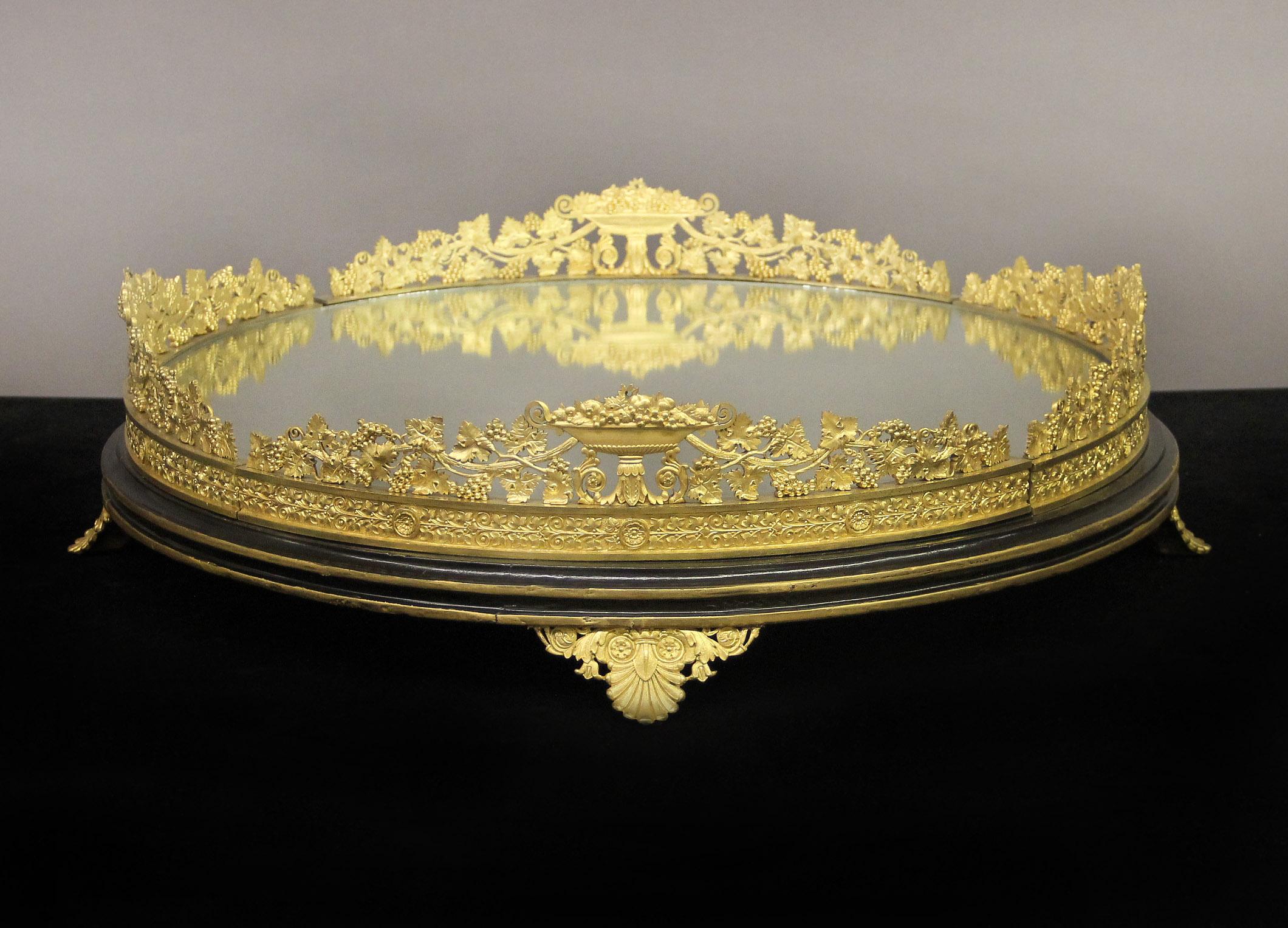 Fantastique table Surtout de table de la fin du 19ème siècle en bronze doré et miroir

De forme A, il est composé d'une galerie de bronze en forme de vigne et de pièces centrales remplies de fruits, d'une base en miroir ajustée et repose sur quatre