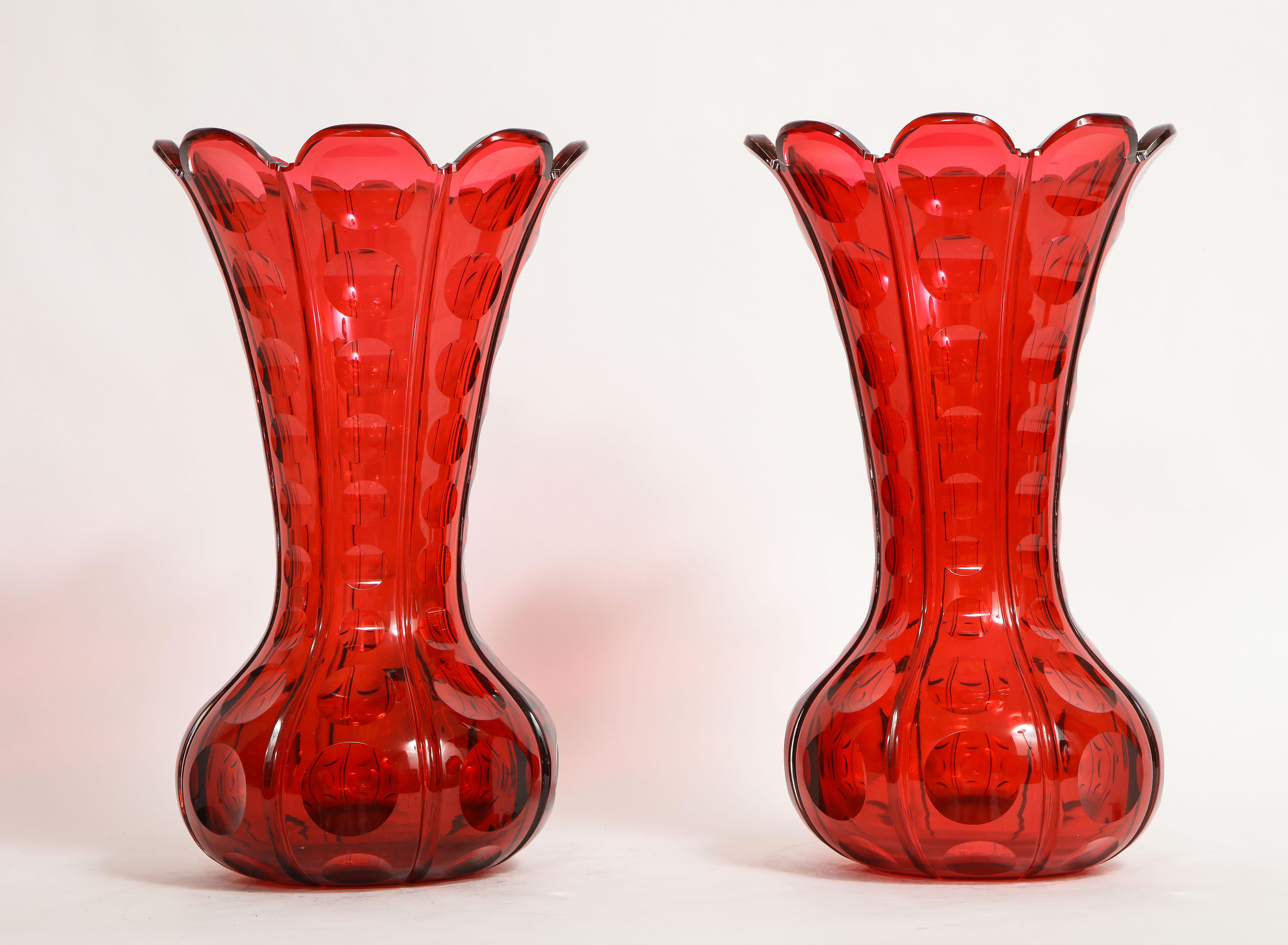 A Fantastic and Rare Pair of 19th Century French Baccarat Ruby Red Crystal Vases of Magnificent Quality. Each is beautifully hand-carved and detailed with the finest ruby red crystal manufactured by Baccarat in France. They are designed like two