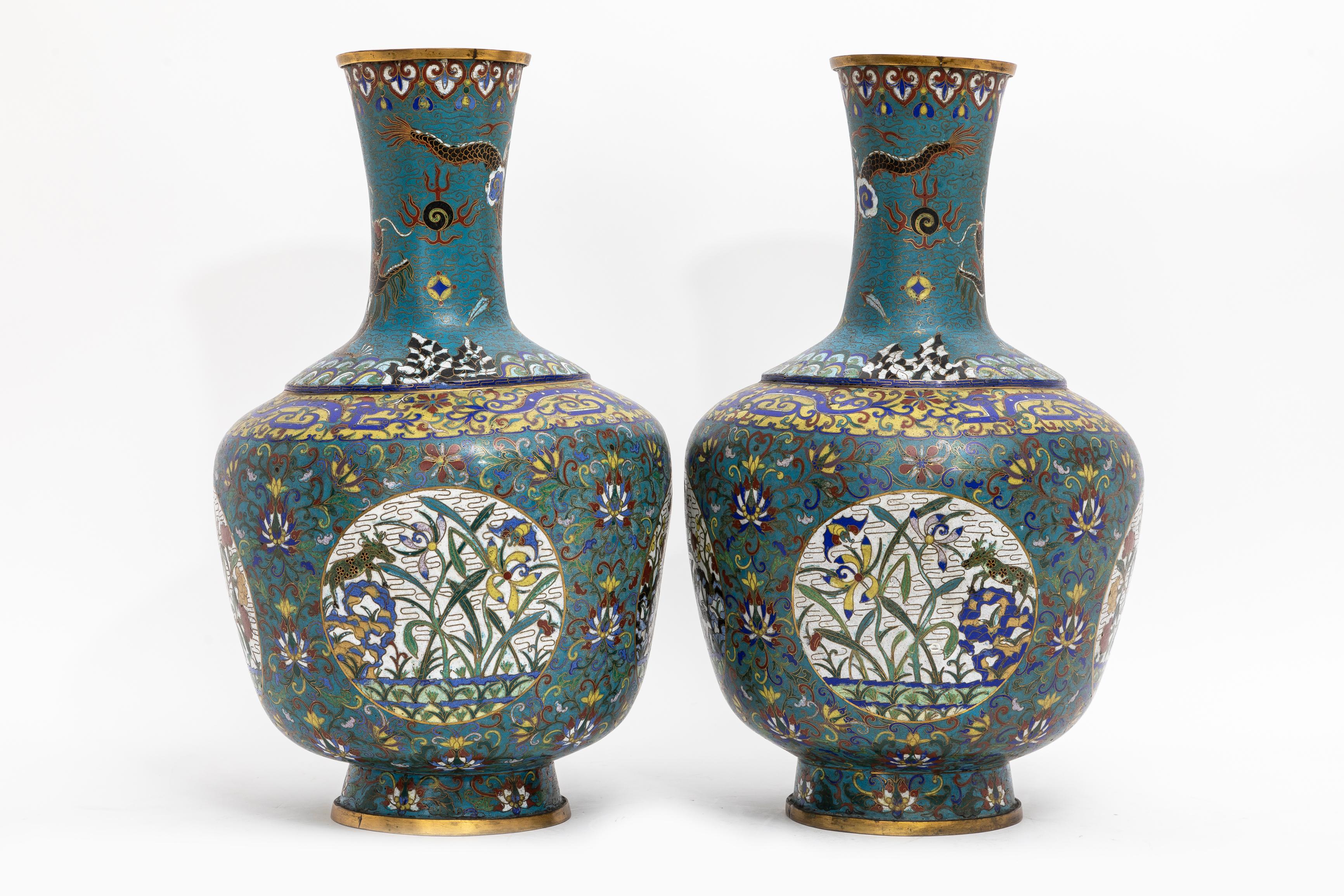 Fantastica coppia di vasi di draghi cloisonné a fondo turchese del XIX secolo.  Ogni vaso è costruito con una forma a balaustro che sale fino a un collo alto e svasato e poggia su un piede circolare leggermente strombato. Il collo è delimitato da
