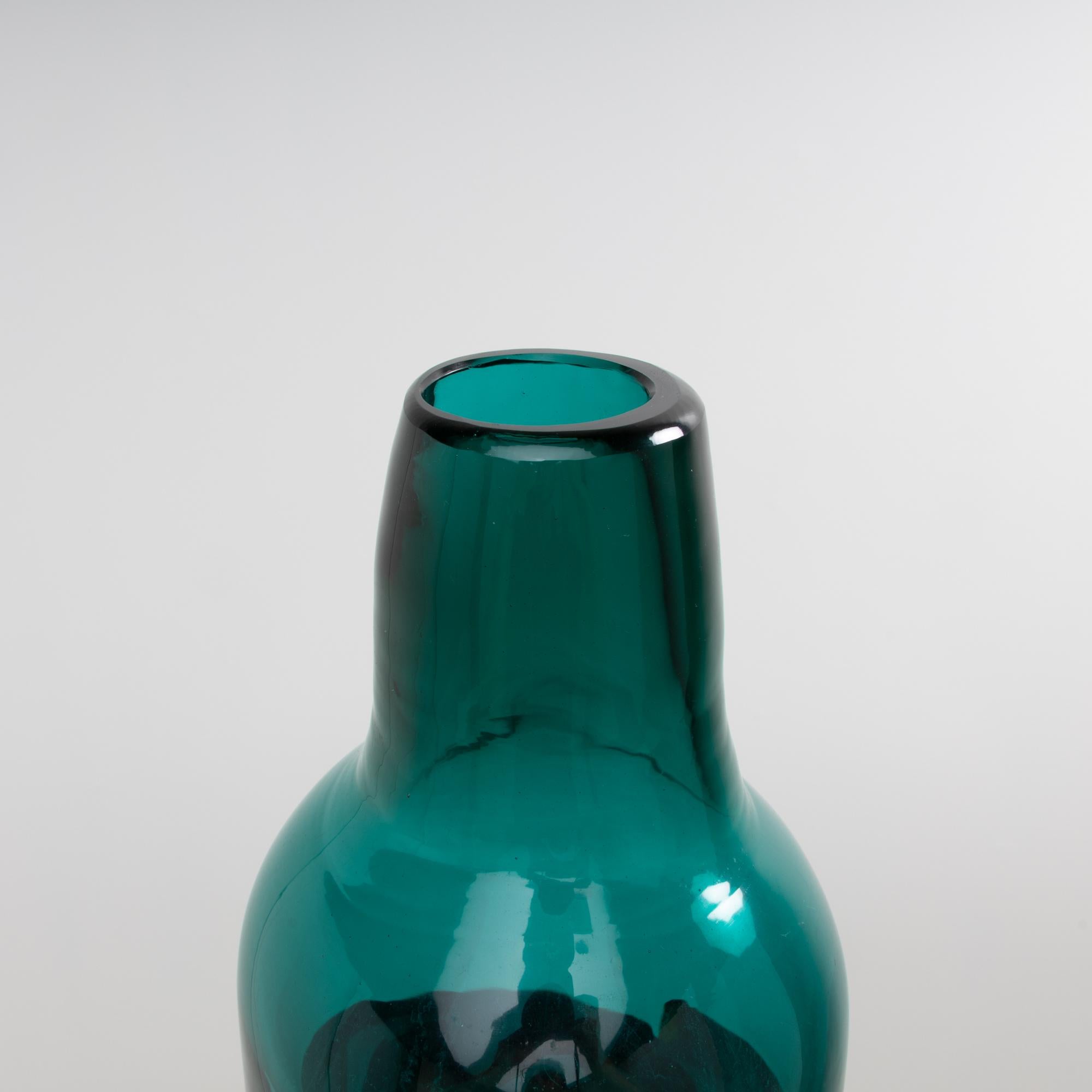 Large green blown glass bottle vase decorated with three hot applied red bands (on a white background). 
 
Very imposing by its size of 61. cm, we have not found the similar model in the Venini archives, it is a variant of the model referenced