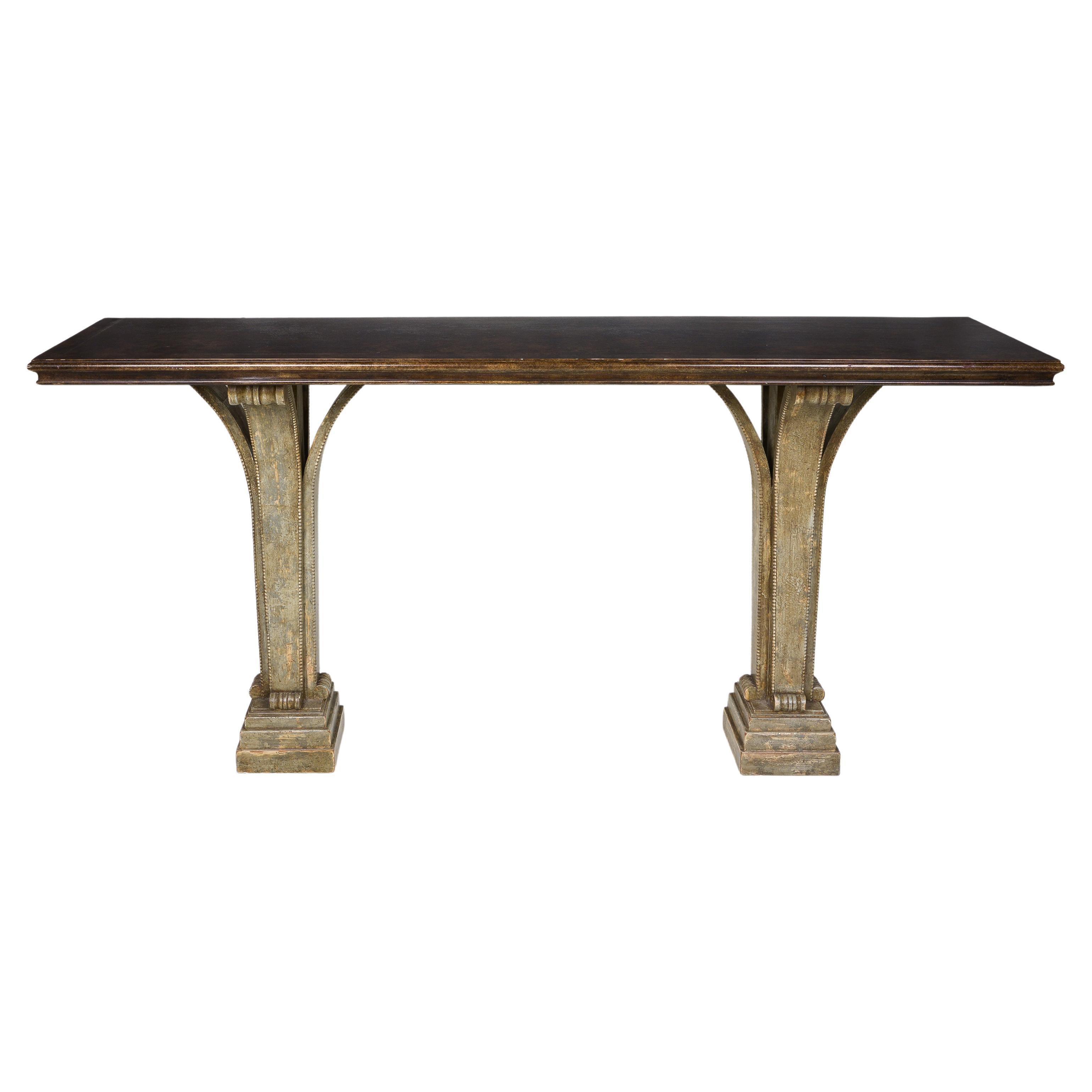 The rectangular top with cavetto molded edge faux painted to evoke stone; rained standing on two square pedestals formed by three outward scrolling supports with beaded trim, on stepped plinths.