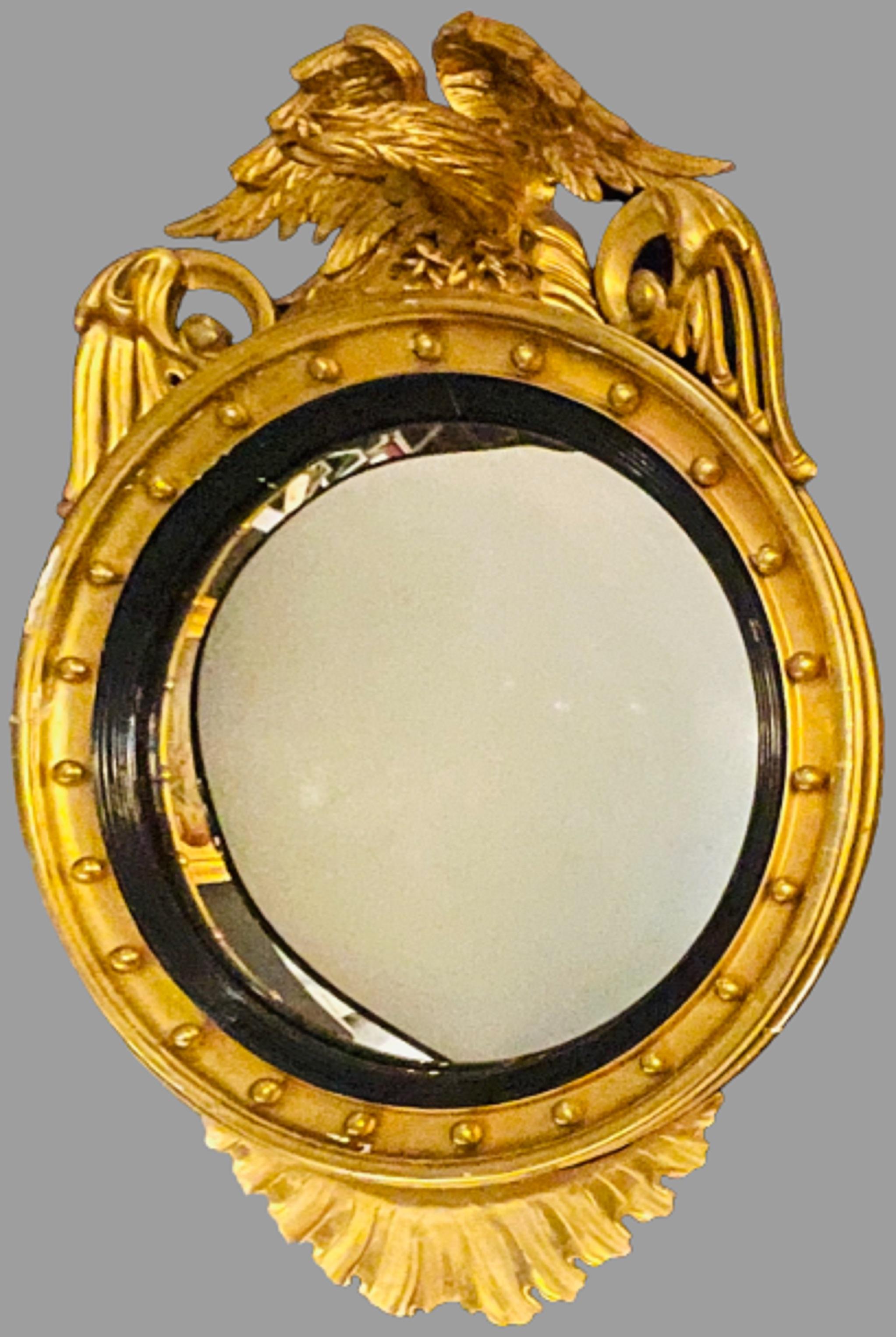 A Federal style gilt gold convex
Wall mirror. Wall, console or pier mirror that is simply stunning. This large and impressive gilt gold mirror has a convex or bowed center clean mirror flanked in a giltwood frame done in the Federal style. The