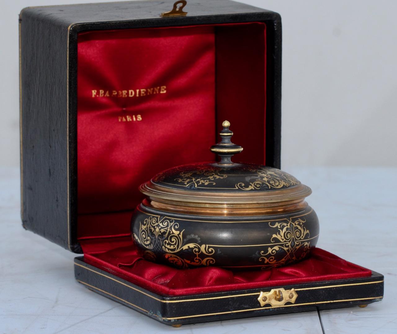Ferdinand Barbedienne (1810-1892)
A very fine quality damascene gold and silver inlaid and patinated bronze circular box, circa 1875
In original black leather and red silk fitted box (H 10 cm, W 14 cm, D 12 cm).
   