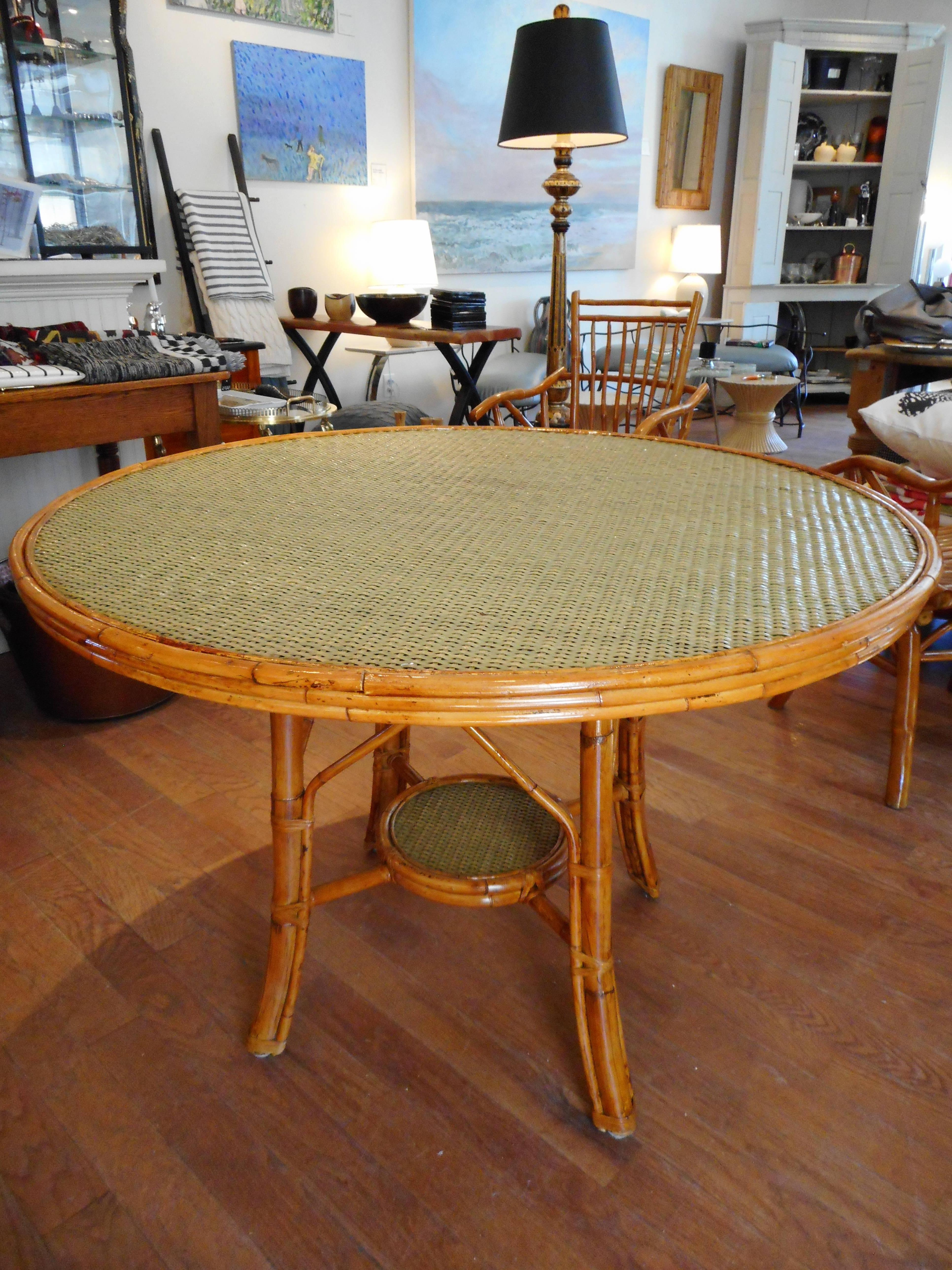 A rare find in this very shapely midcentury Ficks and Reed bamboo dining set.The table has a sage green woven caned top, and bottom shelf tier (caned) the frames of all pieces are constructed of strong bamboo with a lacquer finish ,beautiful