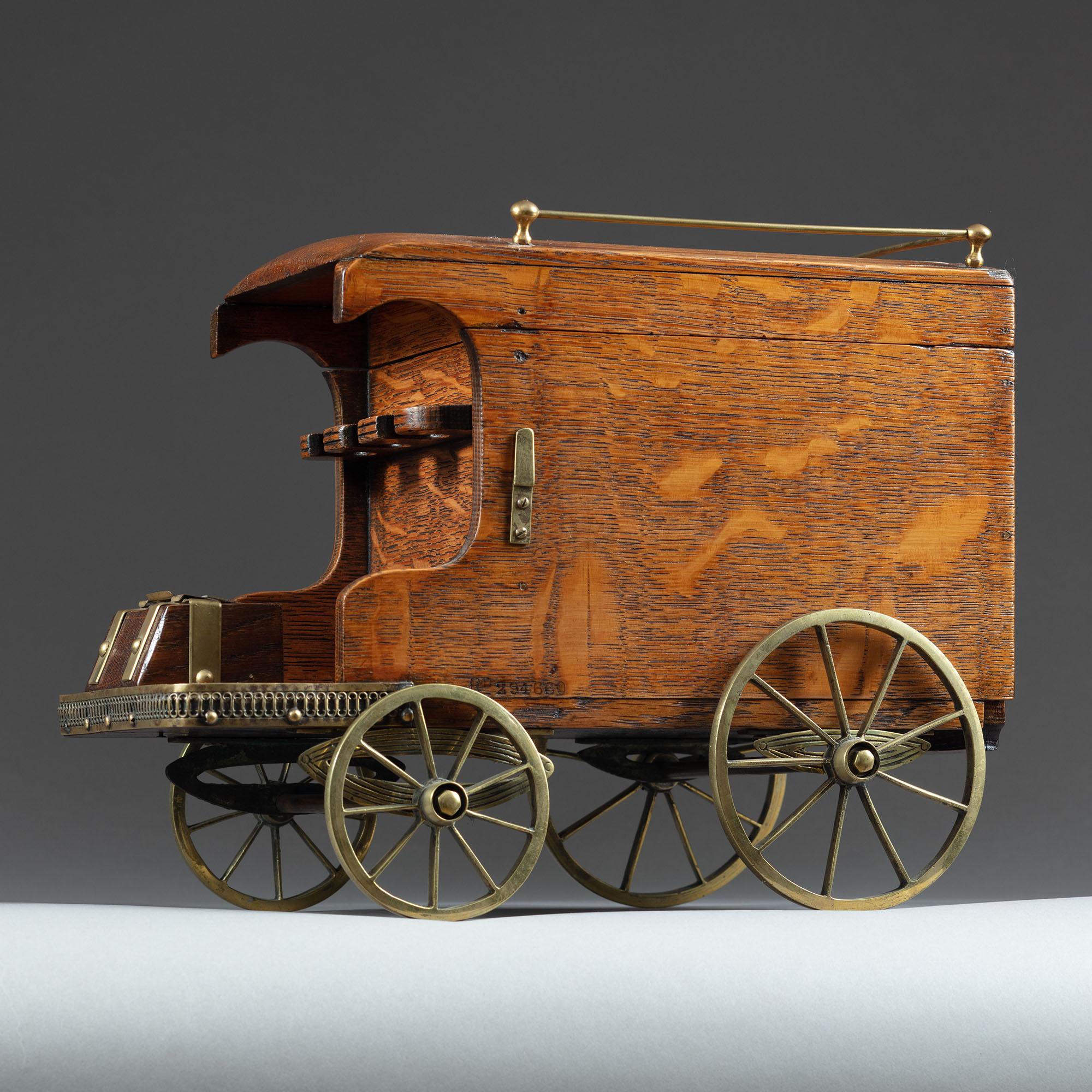 Compagno per fumatori in Oak di grande carattere, a forma di furgone per le consegne trainato da cavalli, datato 1897, con coperchio incernierato e binario che racchiude due vani portaoggetti, con portapipe e custodia per la vesta nella parte