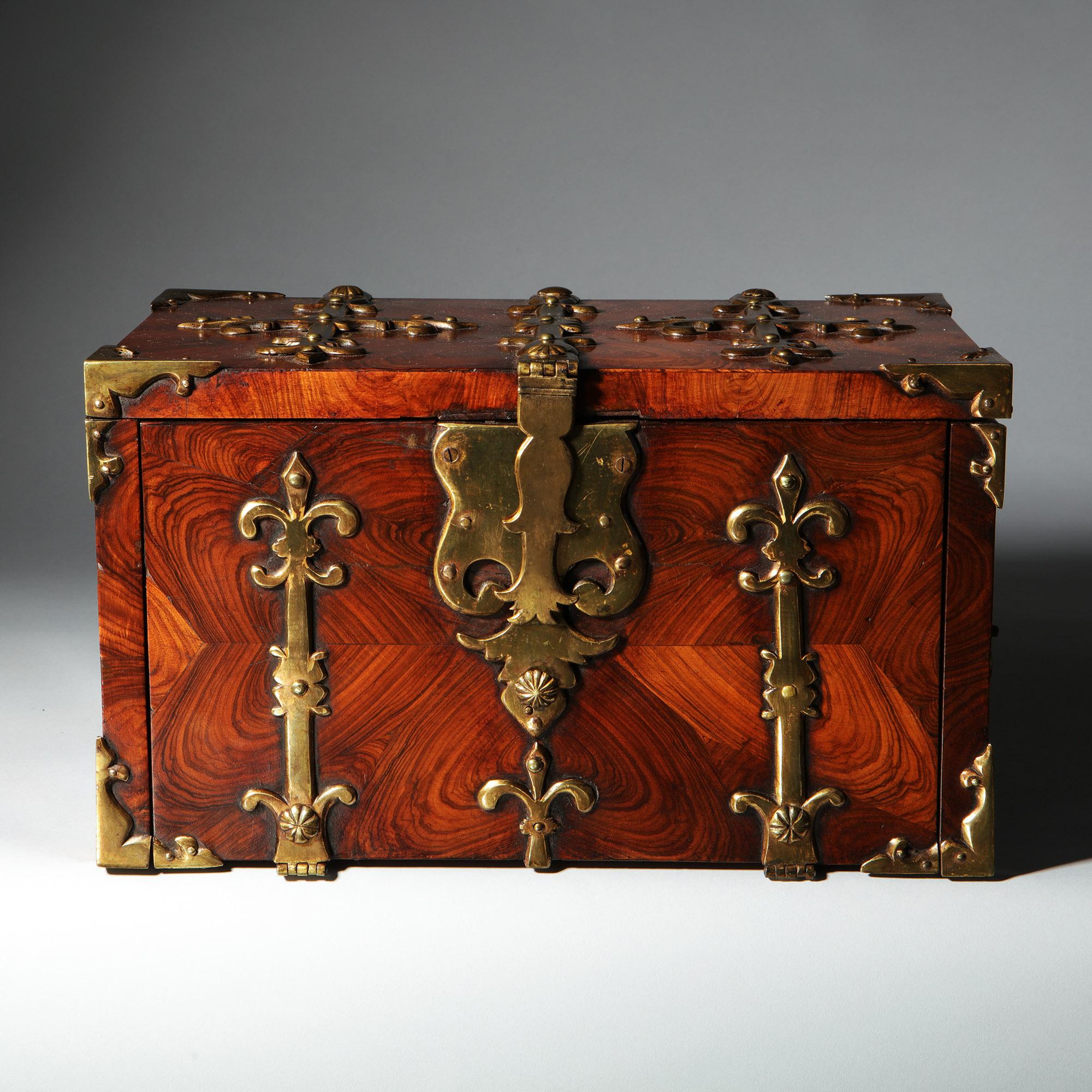 A William and Mary Kingwood/Princes oyster strongbox or Coffre Fort, circa 1680-1700, England. Adorned with highly decorative gilt brass strapwork and decorated in knife-cut oysters of kingwood, this box is fit for the most discerning of collectors.