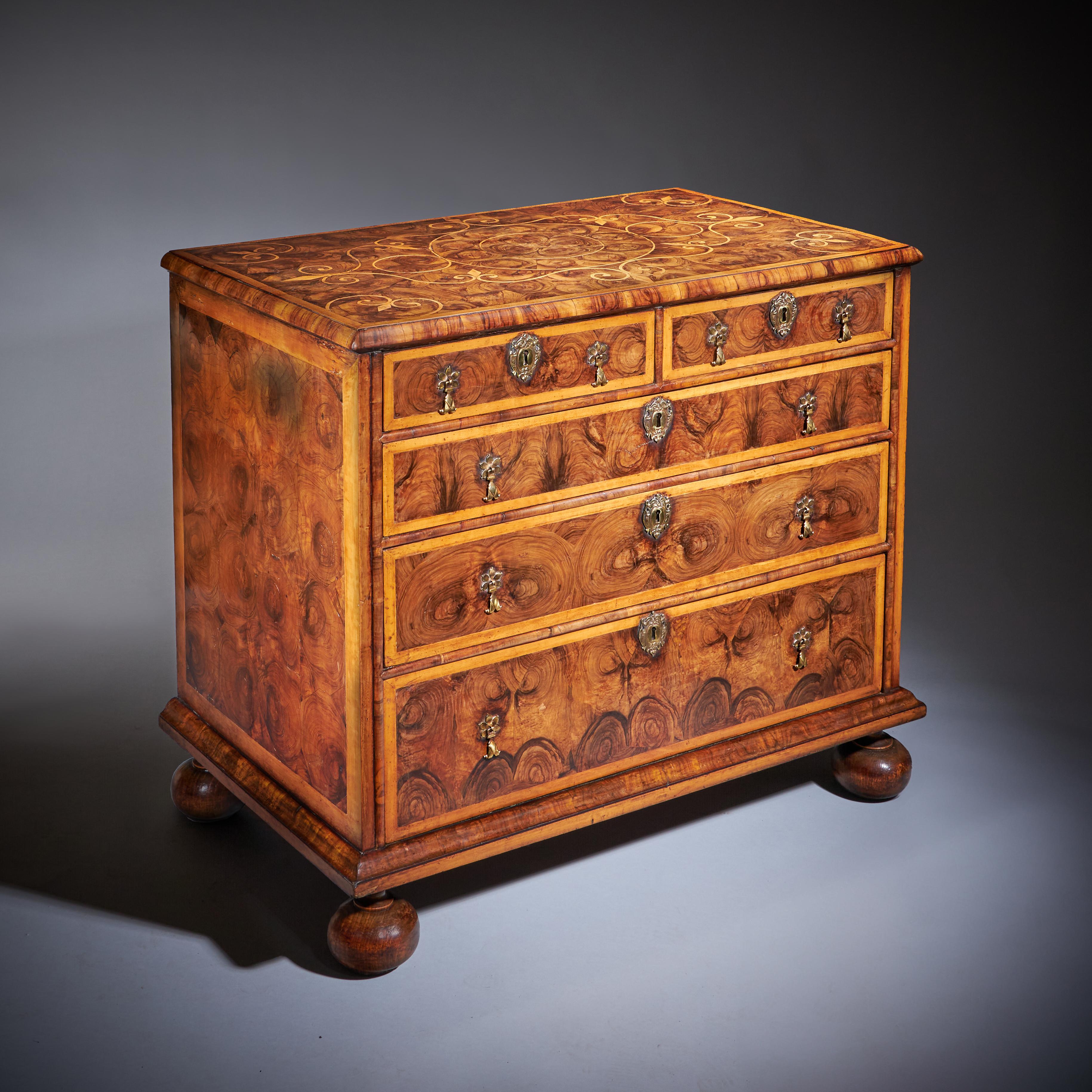 Questa squisita cassettiera d'epoca William & Mary, realizzata alla fine del XVII secolo, mostra un'eccezionale maestria sia nella forma che nel materiale. La cassapanca è costruita in legno d'ulivo riccamente patinato e presenta la ricercatissima