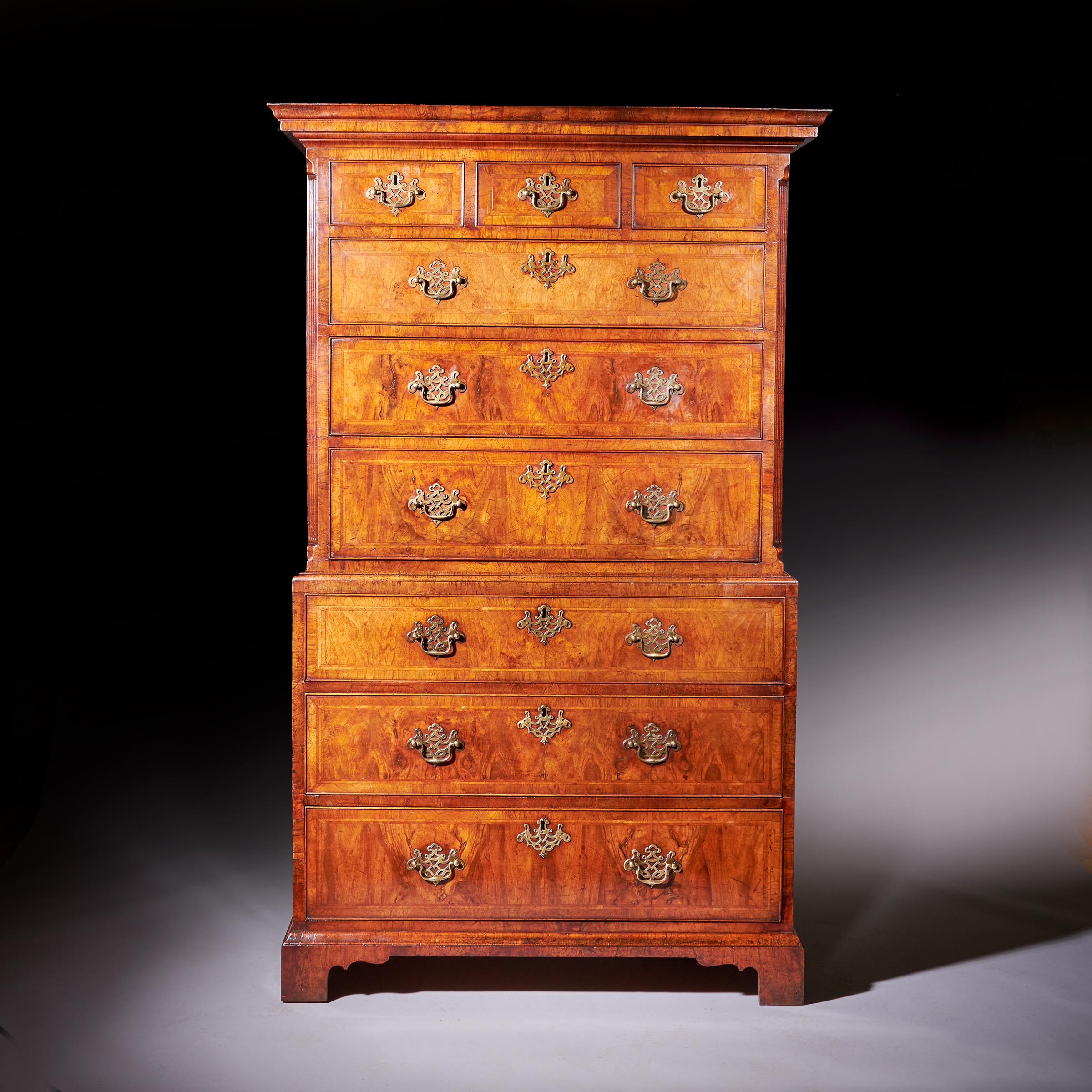 Un raffinato cassettone in noce figurato del XVIII secolo di Giorgio II, CIRCA 1740. Inghilterra. 

In due parti divise da una modanatura a venature incrociate, la sezione superiore è costituita da una complessa cornice a venature incrociate che